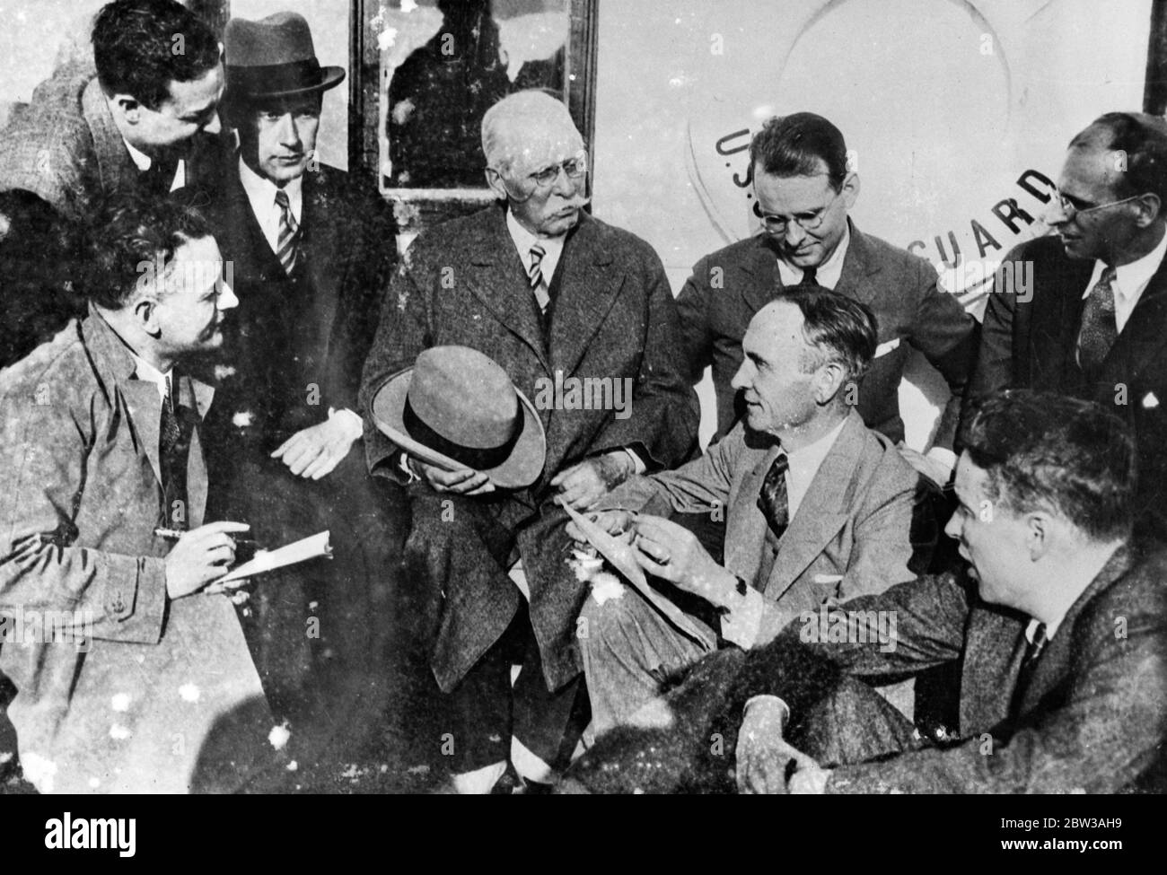 Samuel Insull , former utilities magnate , is pictured centre , as reporters plied him with questions aboard the Coast Guard cutter USS Hudson , to which he was transferred upon his arrival in New York harbour , May 7 aboard the SS Exilona . On his left is Burton Y Berry US embassy attache in Istanbul , under whose custody Insull made the trip to the United States . The cutter brought Insull to Fort Hancock , where he was placed in an automobile , taken to a railroad station and put aboard a train for Chicago , where he will placed on trial for embezzlement . 7 May 1934 Stock Photo