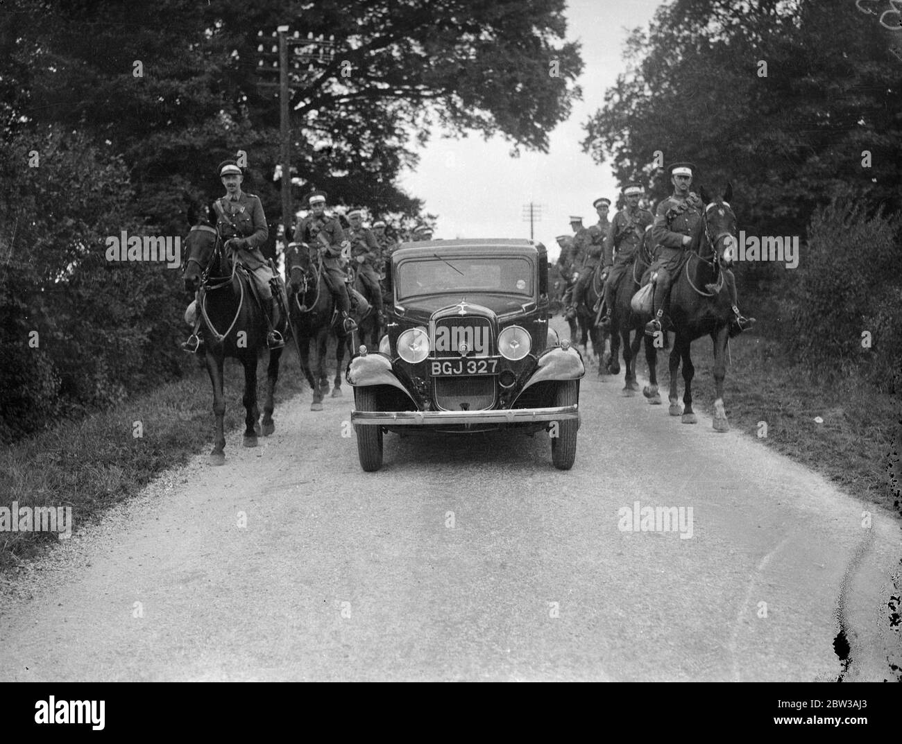 The 1st Life Guards engaged in the army manoeuvres on Salisbury Plain , unwittingly formed a Guard of Honour , for a private motorist on the road in Wiltshire . The ' Eastland ' troops are stationed at Charllton Park . They have been attacking selected troops during the early manoeuvres . Photo shows the 1st Life Guard form a Guard of Honour for a motorist near Halesbury . 12 September 1934 Stock Photo