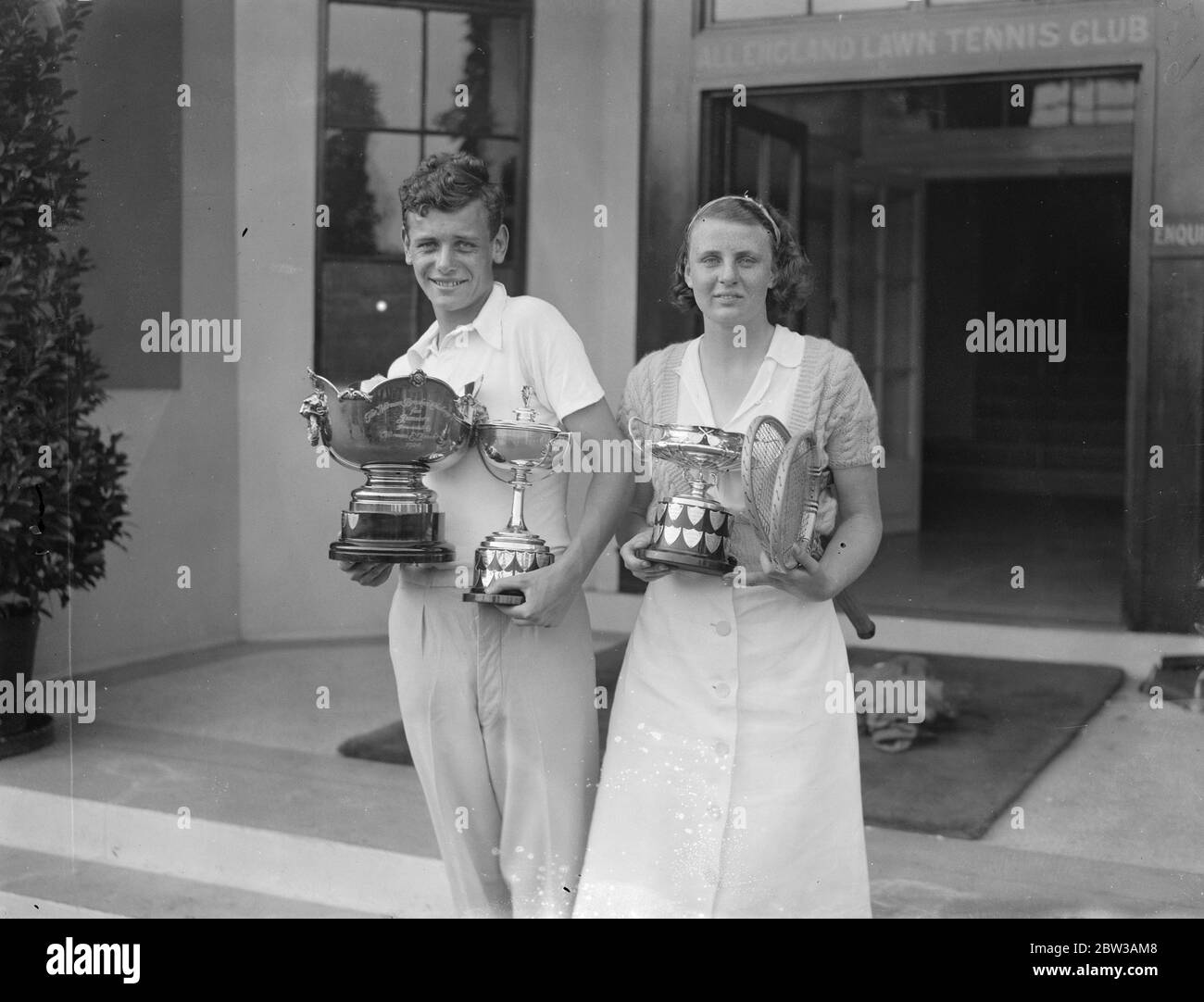 Winners of the ' Boys and Girls ' , tennis championship at Wimbledon . Photo shows Miss D Rowe and R E Milliken with their cups after winning championships . 15 September 1934 Stock Photo