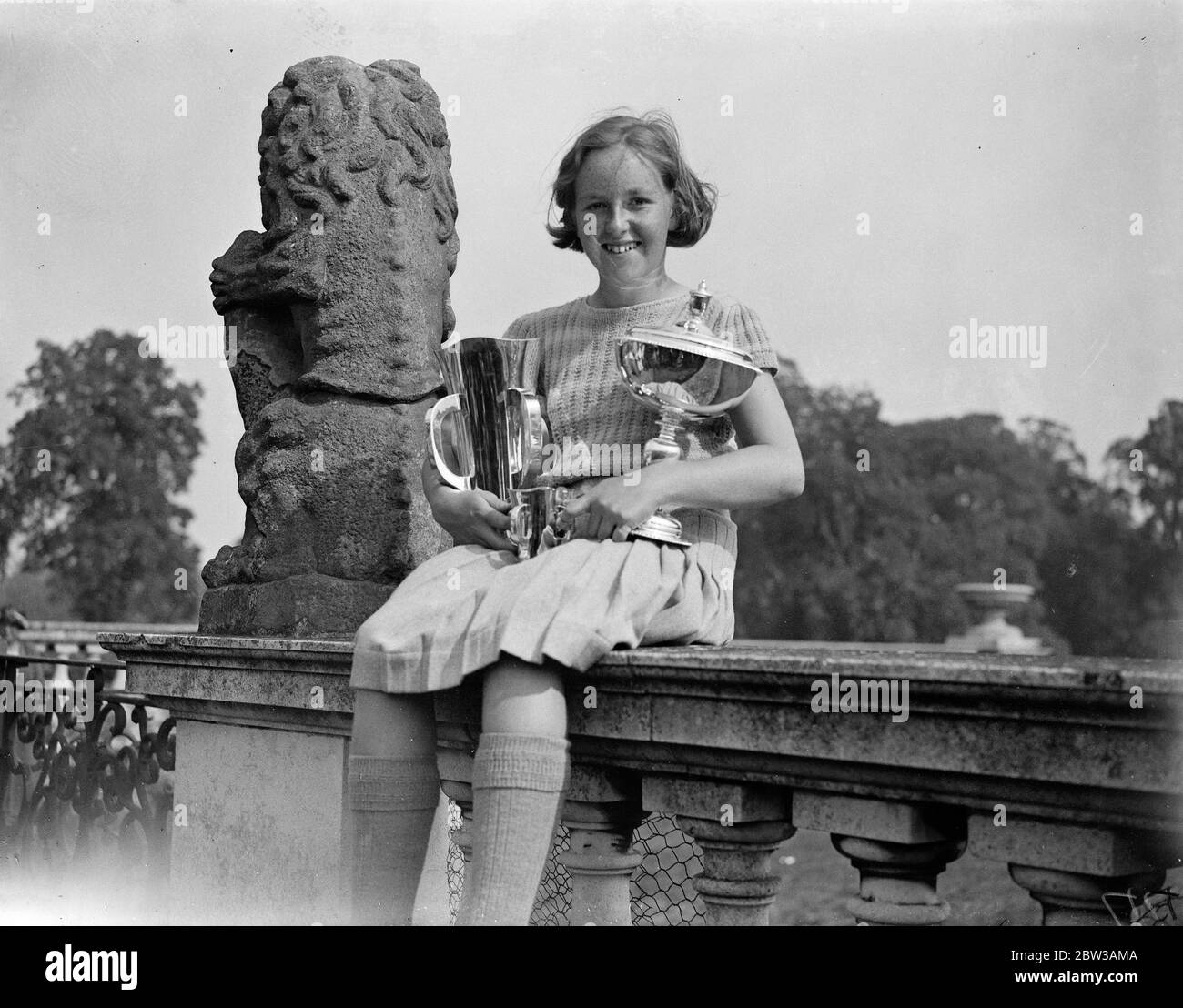 13 year old girl wins golf championships . Little Nancy Jupp 13 year old wonder girl golfer champion holding her cups . 14 September 1934 Stock Photo