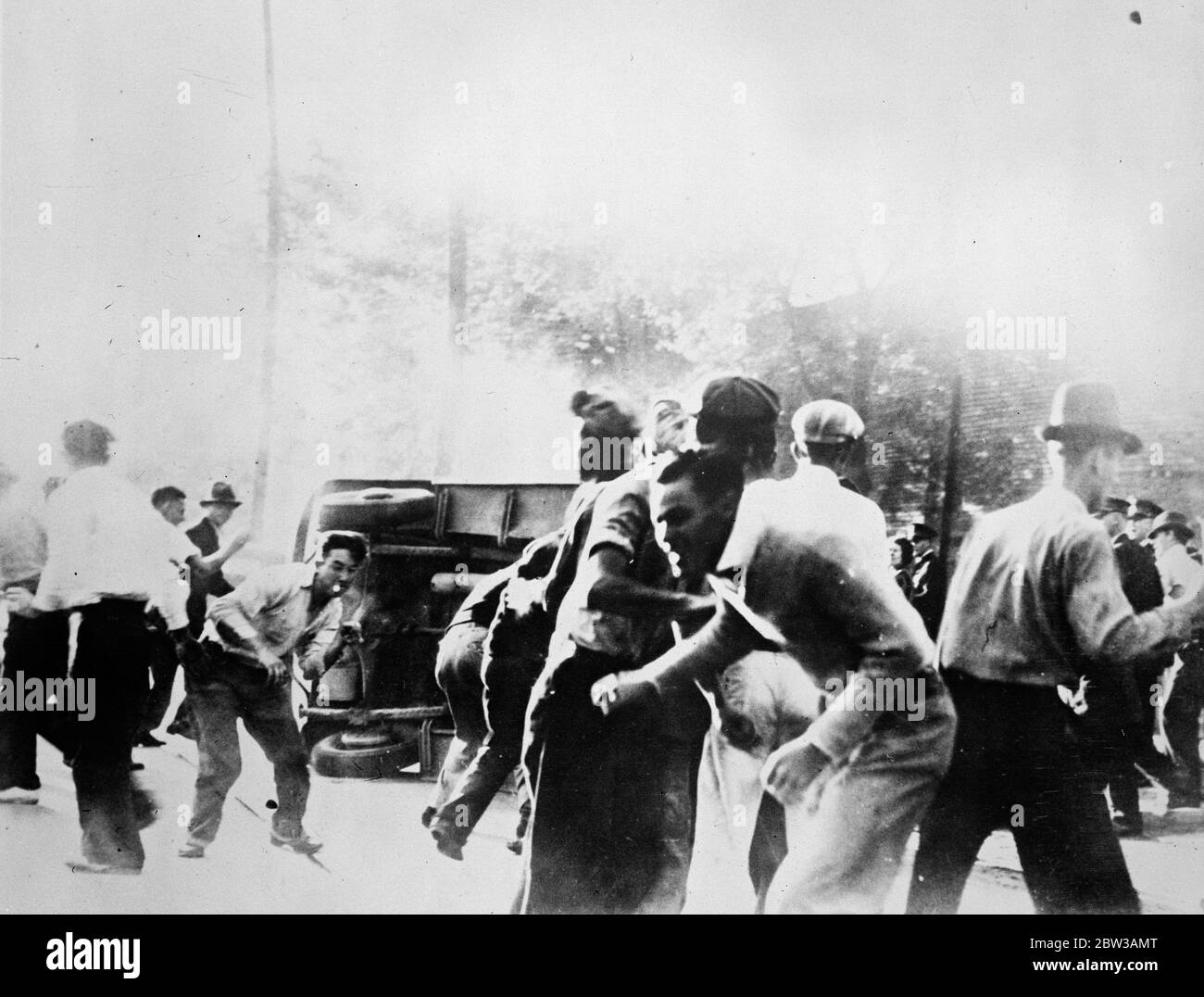 American textile strikers in pitched battle with police . Textile strikers at Macon , Georgia , fought a pitched battle with police after they had overturned and wrecked a motor car which was carrying strike breakers to work . 14 September 1934 Stock Photo