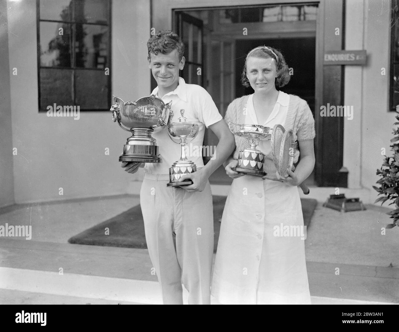 Winners of the ' Boys and Girls ' , tennis championship at Wimbledon . Photo shows Miss D Rowe and R E Milliken with their cups after winning championships . 15 September 1934 Stock Photo