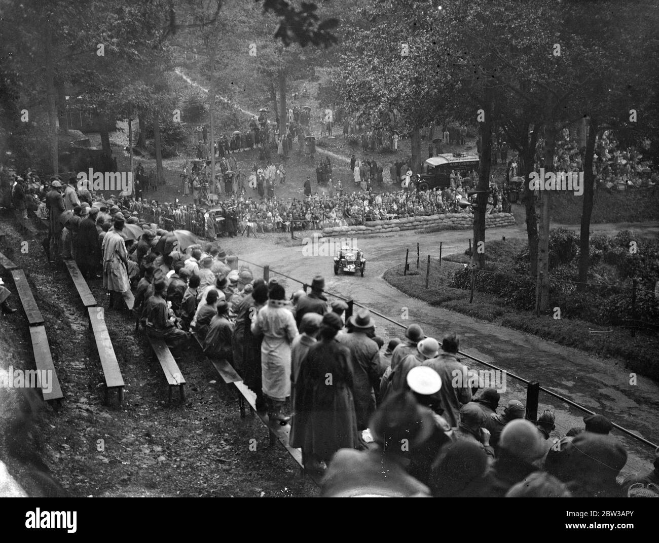 Crowd watches H J Aldington in a Frazer Nash rounding a bend at Shelsley Walsh hill climb . 29 September 1934 Stock Photo
