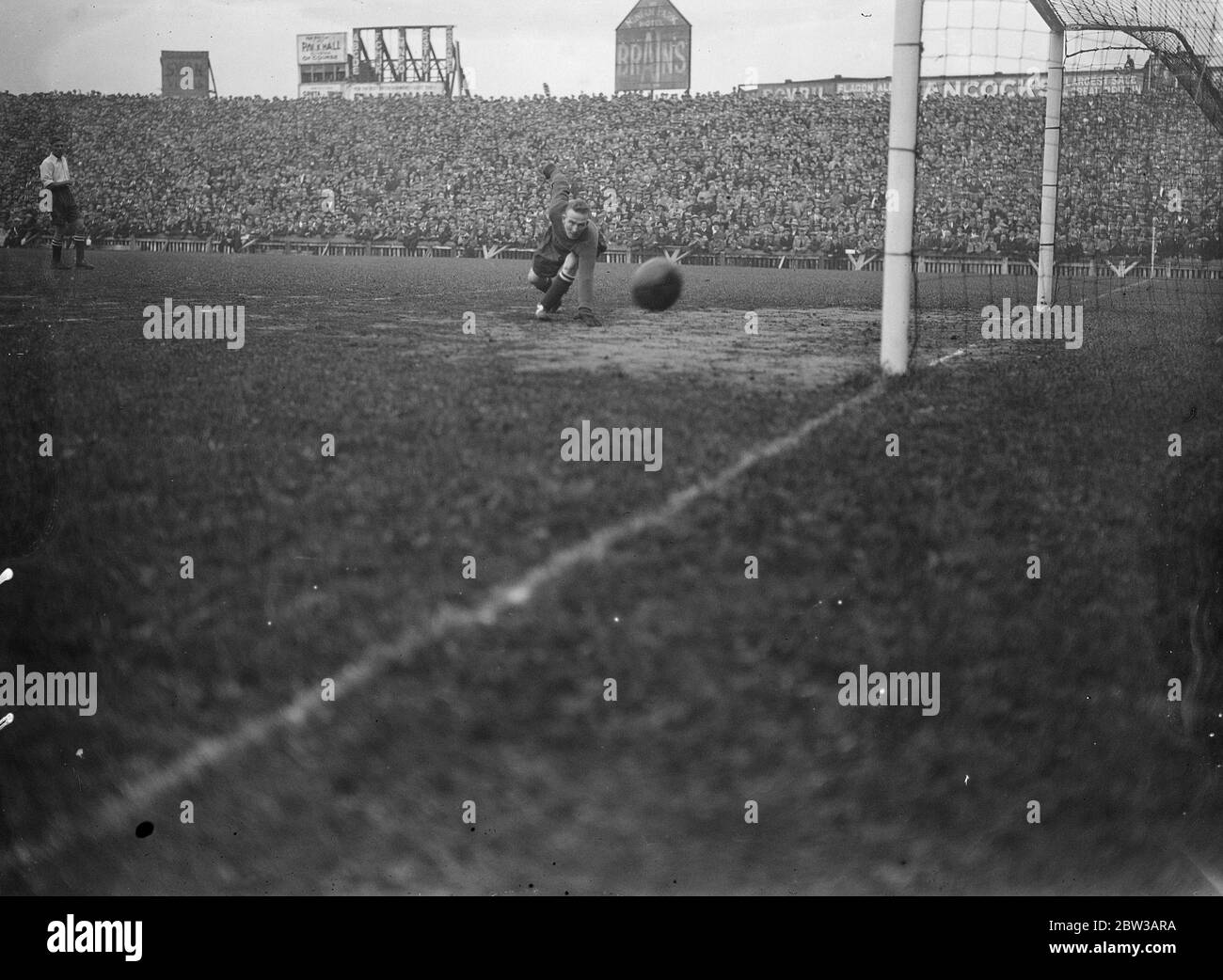 Hibbs saves in international soccer match at Cardiff . England won the first international match of the season when she defeated Wales 4 - 0 at Cardiff . Photo shows Harry Hibbs of Birmingham ( the English goalkeeper ) saving from Tom Evans of Tottenham Football club ( Wales ) during the match . 29 September 1934 Stock Photo