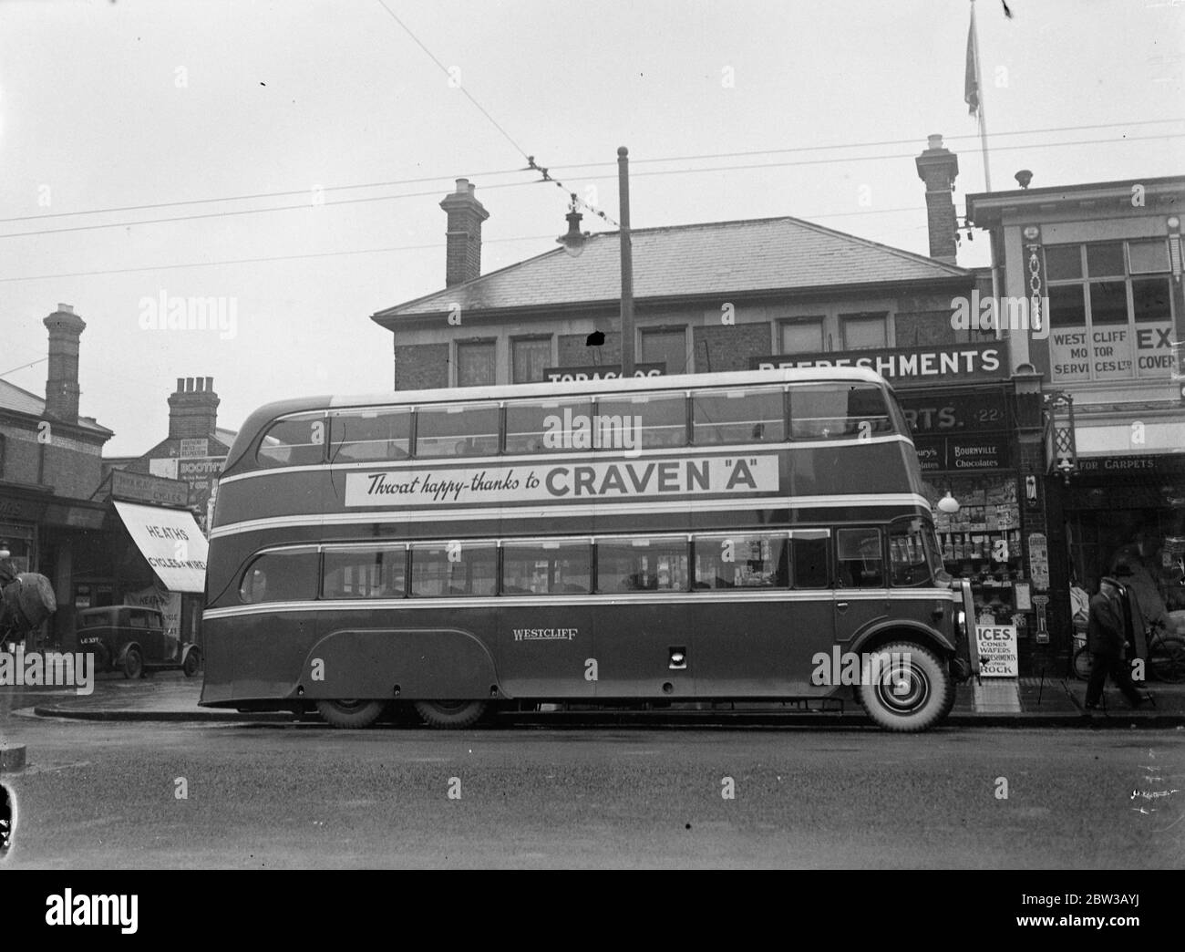 The largest , longest and lowest bus in the British Isles . Picture shows the bus featuring a Craven cigarette advertisement on its side parked outside shops in Westcliff October 1934 Stock Photo