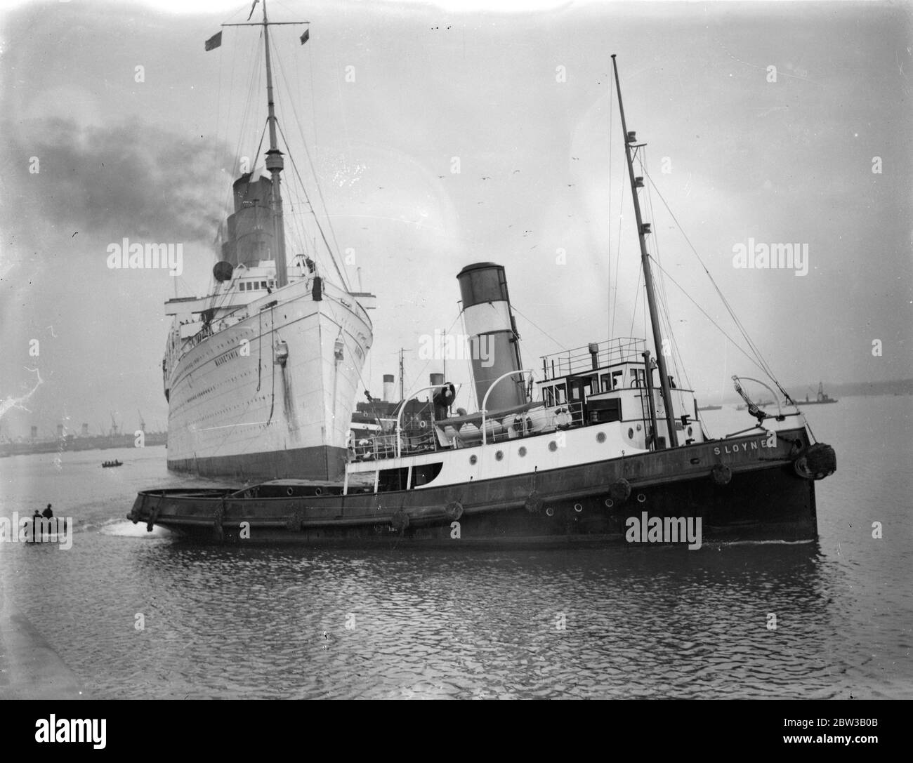 Mauretania to undergo refit not to be scrapped . Picture shows ship being towed into port by tug boat . 3 October 1934 Stock Photo