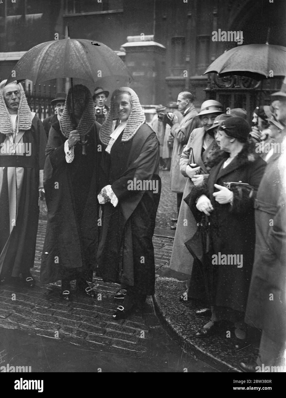 3 judges sheltering under an umbrella outside Westminster Abbey . 2 October 1934 Stock Photo