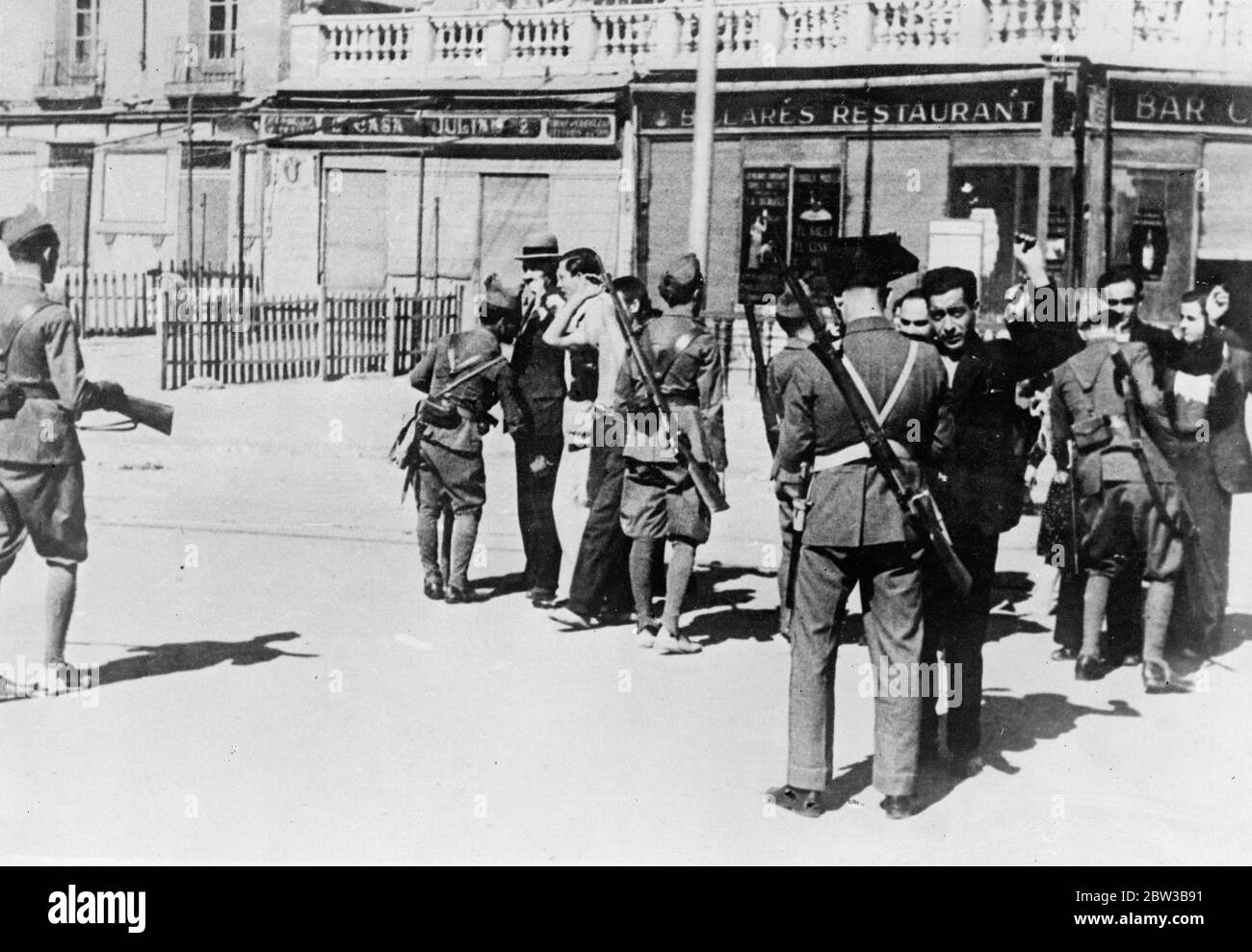 Police search pedestrians on the streets of Madrid after the outbreak of the civil war . 9 October 1934 . Stock Photo