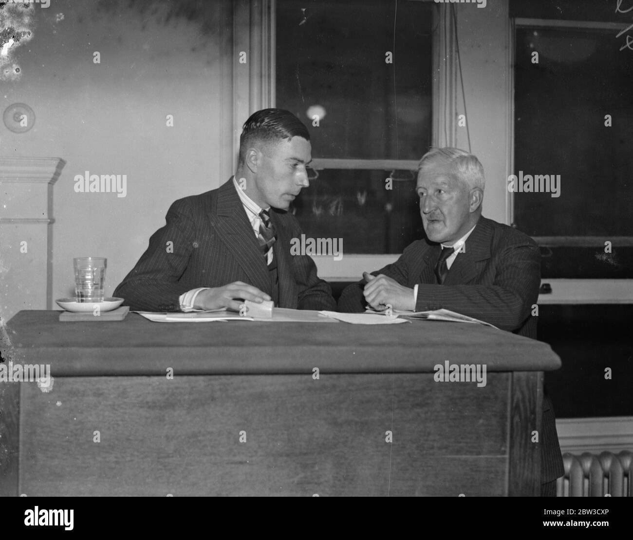 £7,500 bid for famous British Guiana stamp at London auction . Mr P L Penherton ( right ) discussing the proposed negotiations with Mr Guy Harmer , junior , the auctioneer , after the auction . 30 October 1935 Stock Photo