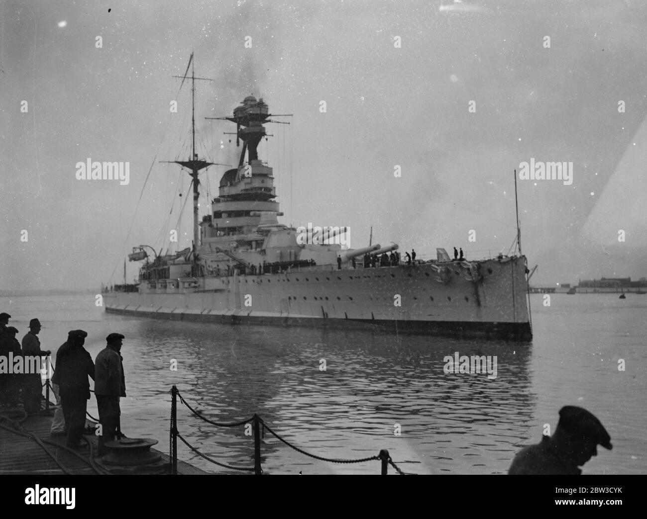 Battleship home from the mediterranean . Sailors will spend christmas in England . the 29 , 150 ton battleship HMS Resolution (pennant number 09 ) arrived at Porstmouth from Alexandria after having completed more than two years service on the Mediterranean station . Many sailors from other warships were aboard her as well as her own crew so that they could spend christmas at home . The HMS Resolution bes been relieved by HMS Ramillies ( 07 ) which is of similar class and tonnage . Photo shows , HMS Resolution arriving at Portsmouth . 5 November 1935 Stock Photo