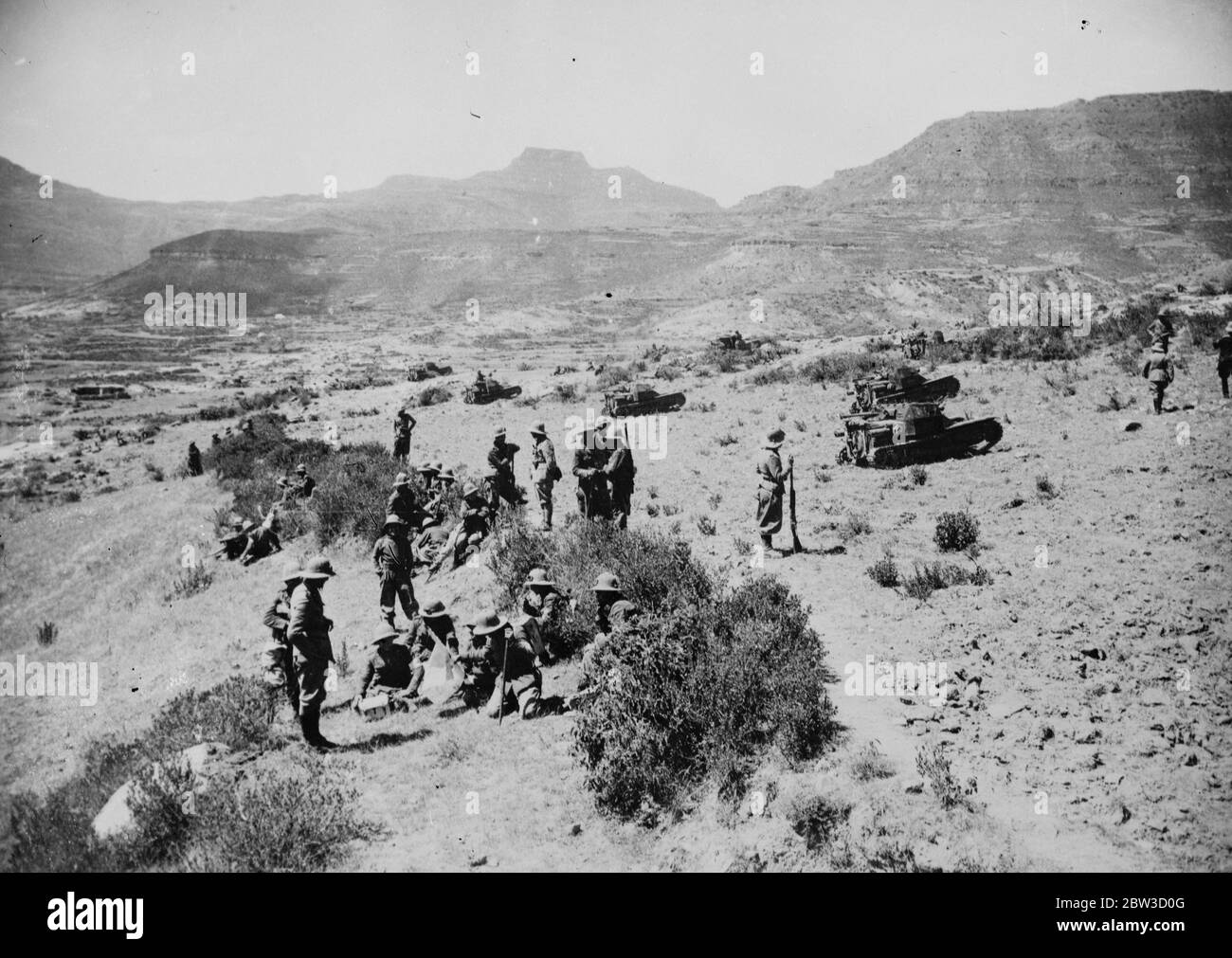 Infantry and tanks in advance . Italian infantry and tanks making a brief pause in the wild desert country beyond Adigrat during their advance . 26 October 1935 Stock Photo