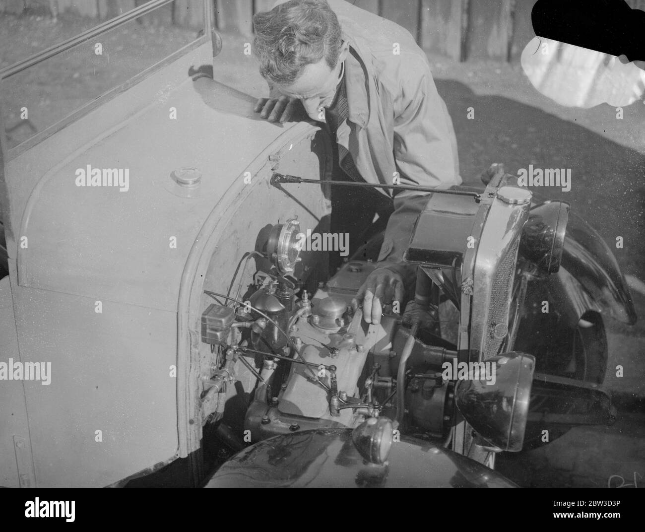 First diesel engined light car test . 65 miles for a shilling in eight horse power baby . Examining the engine of the new diesel light car . The car is the Victor Diesel Cub . 10 October 1935 Stock Photo