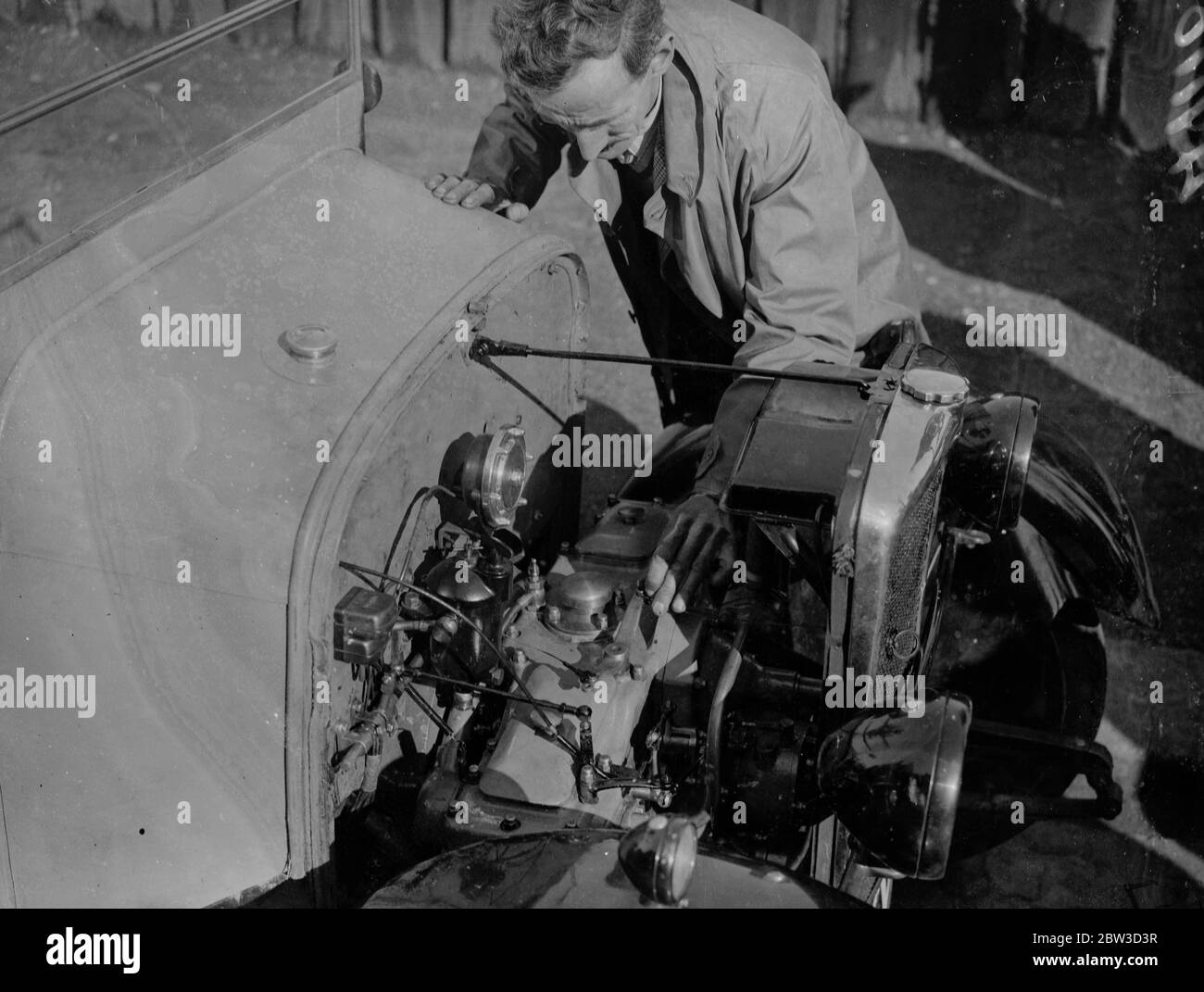 First diesel engined light car test . 65 miles for a shilling in eight horse power baby . Examining the engine of the new diesel light car . The car is the Victor Diesel Cub . 10 October 1935 Stock Photo