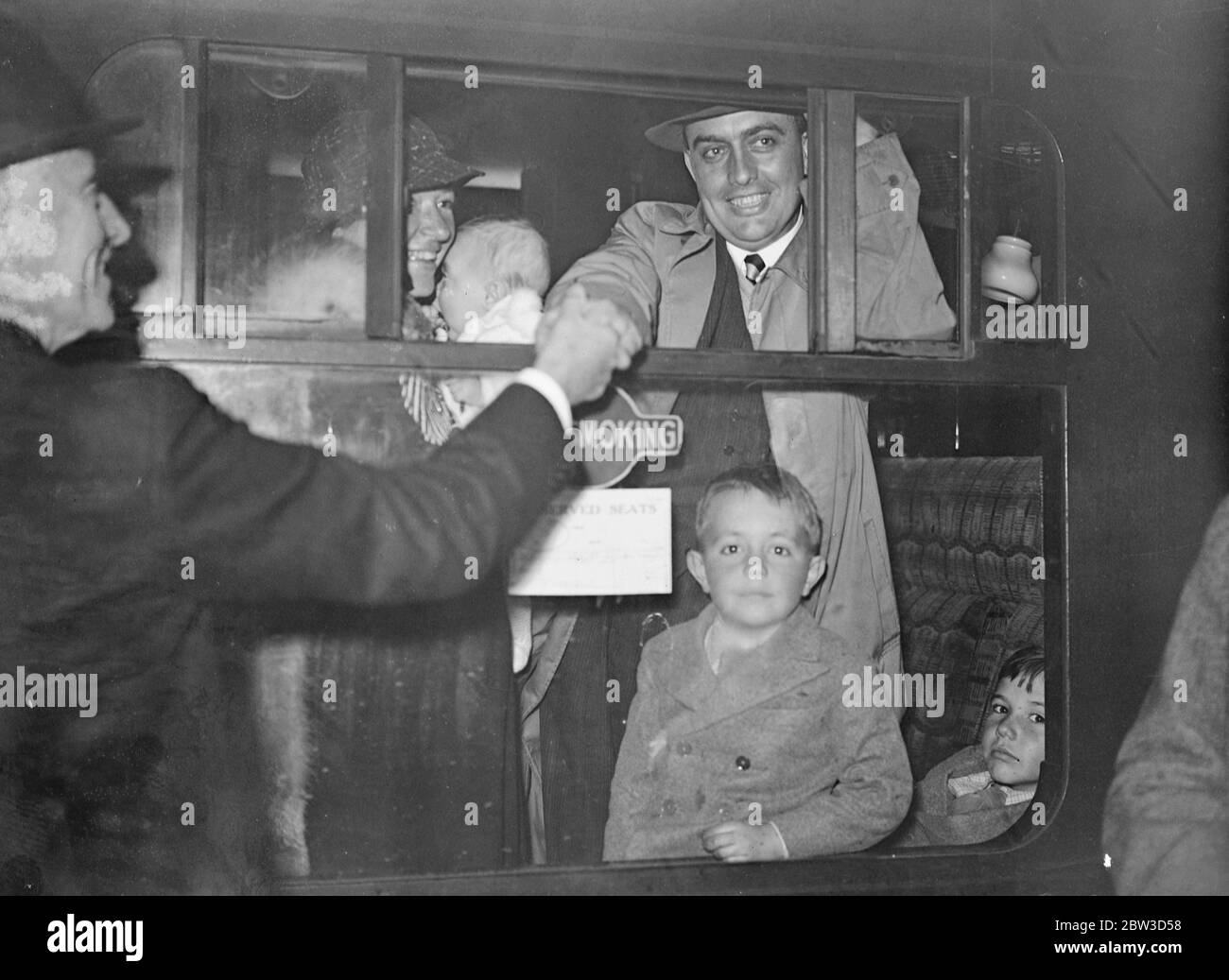 London doctor leaves with wife and three children to take charge of India 's largest leper colony . Dr Robert Cochrane with his wife and two of his children saying goodbye to friends at Euston station , London . 11 October 1935 Stock Photo