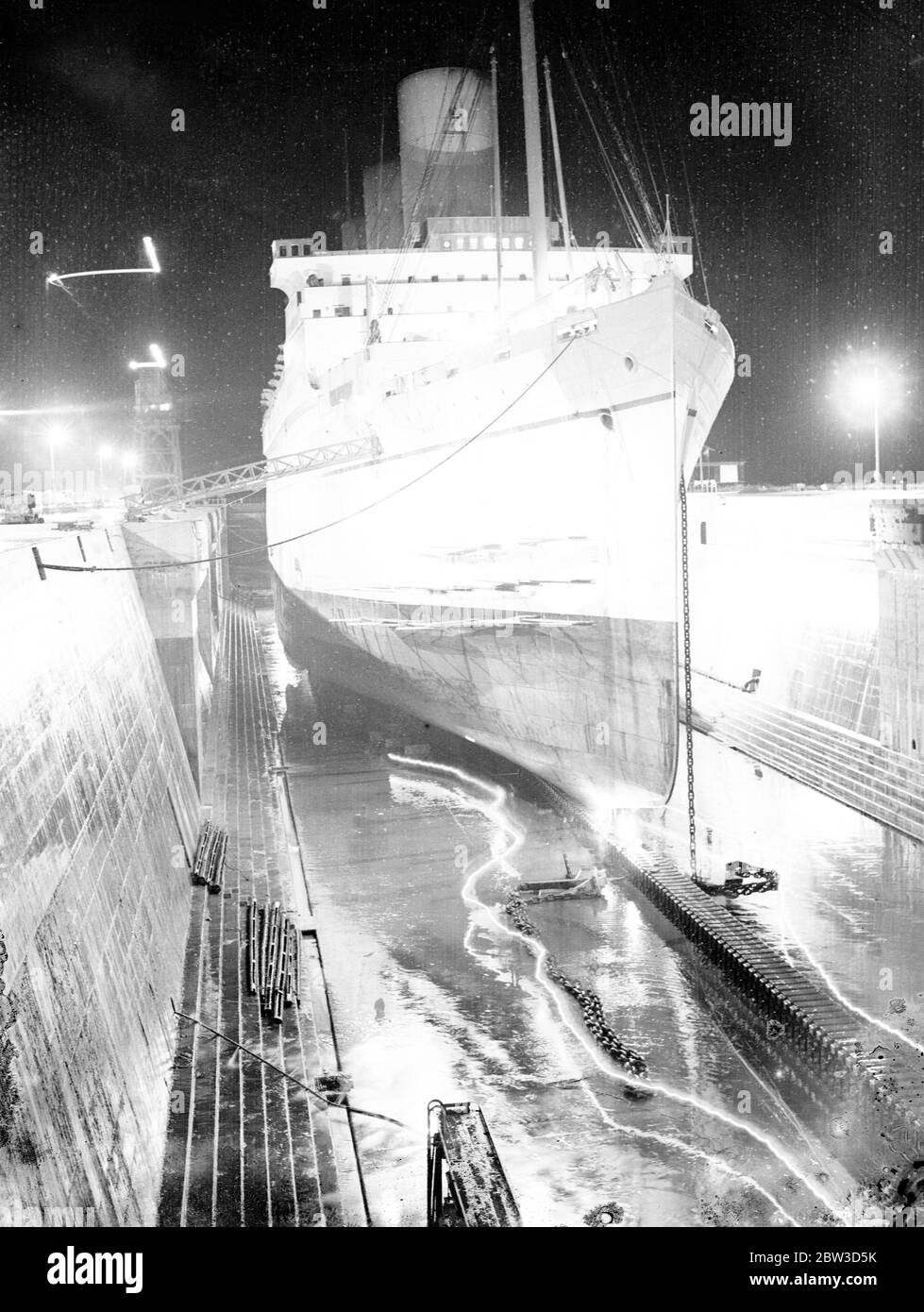 The Empress of Britain floodlighted . The plates in the bows of the Empress of Britain which were damaged when the ship came into collision with the Kafiristan in the St Lawrence River in the summer are being renewed in drydock at Southampton , where the liner is undergoing her annual overhaul . Photo shows , the Empress of Britian floodlighted in drydock at Southampton . 16 November 1935 Stock Photo