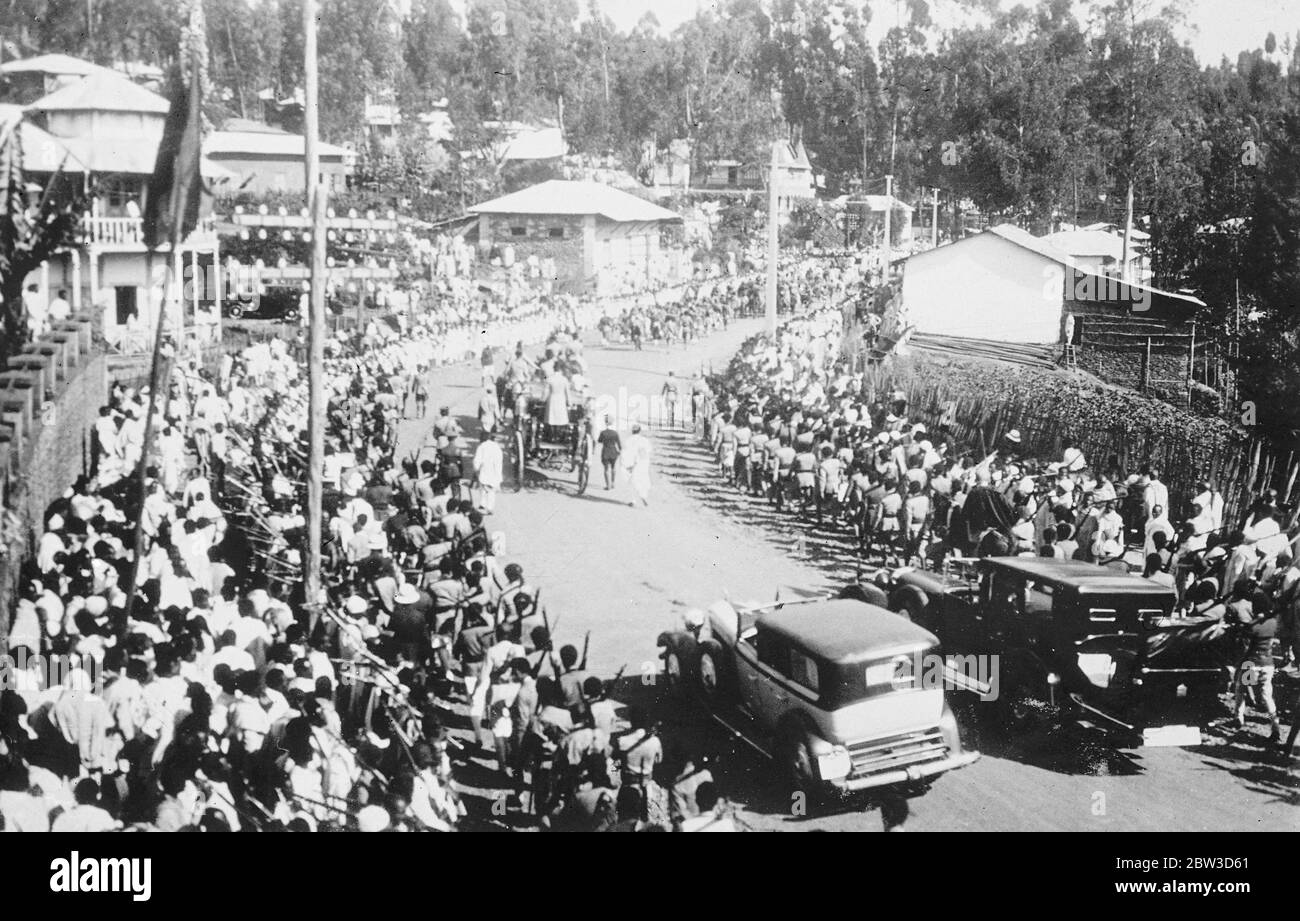 Emperor celebrates in midst of crisis anniversary of coronation . Despite the menace of the Italian invasion the anniversary of the coronation of Emperor Haile Selassie of Abyssinia was celebrated with regal pomp in Addis Ababa . The event was commemorated with a State procession through te town and a great military parade . Thousands of tribesmen led by important chieftains flocked into the capital to pay homage to their ruler and express their loyalty to him in the present crisis . Photo shows , the State procession through Addis Ababa . The Emperor ' s horse drawn coach is in centre of pict Stock Photo