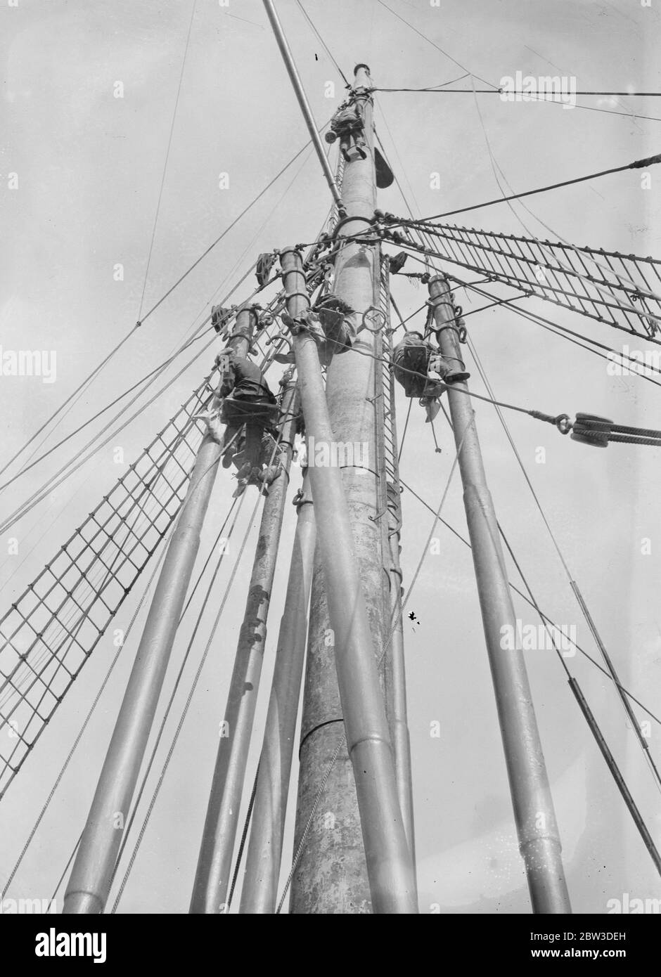 Painters at work in the sky - an impression coveyed by this unusual angle picture made as workmen scraped the old paint from the giant foremast of the Canadian Pacific liner Montealm which is being overhauled at Southampton . 6 November 1935 Stock Photo