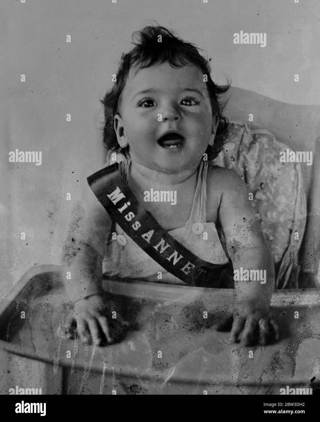 The quins as Beauty Queens . Miss Annette , the pettiest but most mischievous of the quins laughs gaily at the Callander nursery . 16 October 1935 Stock Photo