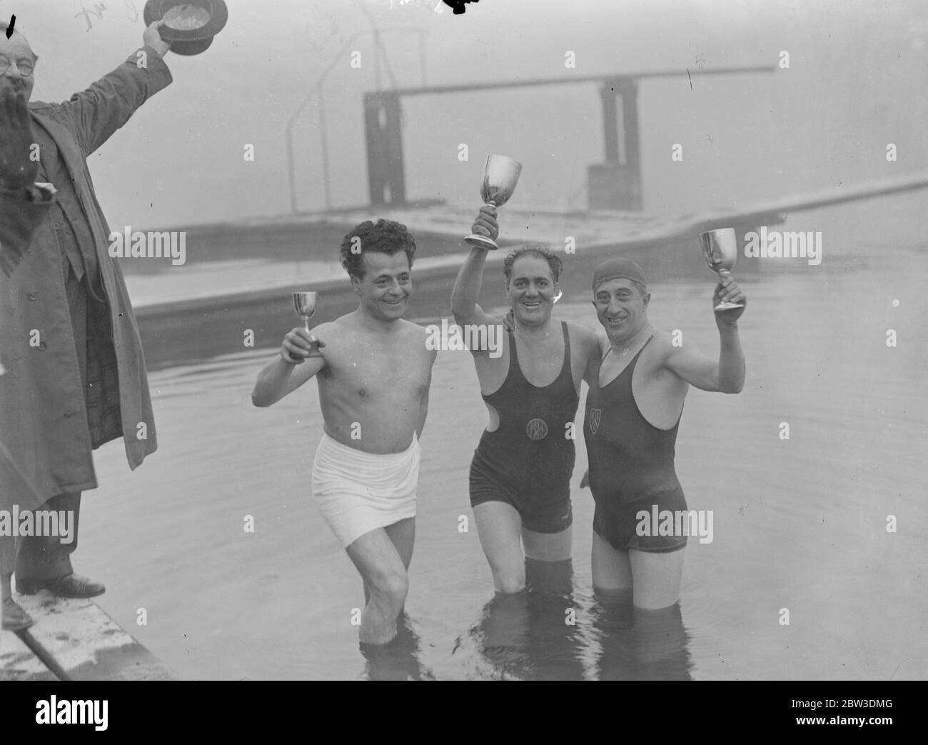 Last Serpentine swimming races of the season held in two degrees of frost . E A Meech , the winner ( centre ) with his cup . On left is E Coda ( third ) and right is Louis Fabre ( second ) . 26 October 1935 Stock Photo