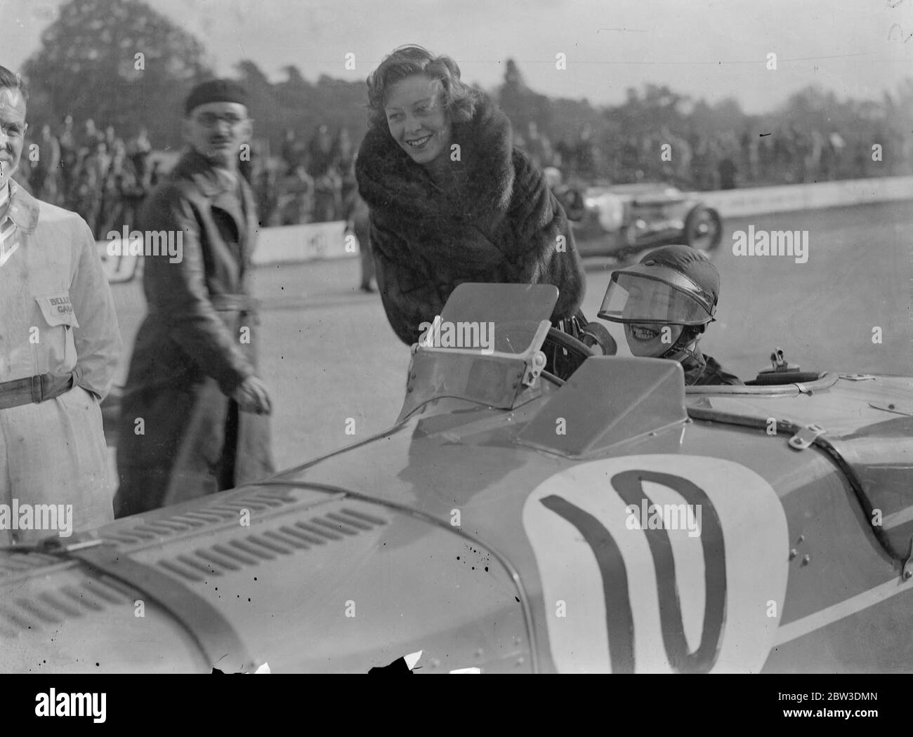 Woman driver at Brooklands autumn meeting . Miss D Evans ( standing ) talking to Mrs D G Evans , her sister in law , who drove an MG in the first race . 19 October 1935 Stock Photo