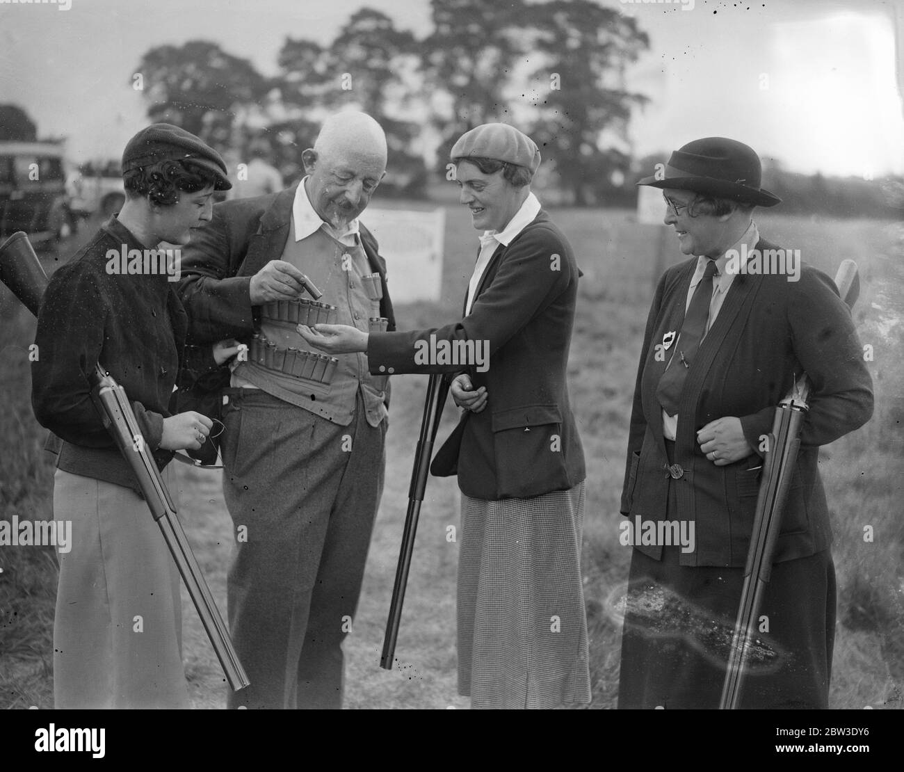 Women compete for clay pigeon championships at Greenford . Photo shows Miss Betty Grosvenor , Mrs Peerd and Mrs Grosvenor , the champion , inspecting Mr Grosvenor ' s cartridge waistcoat . 27 July 1935 Stock Photo