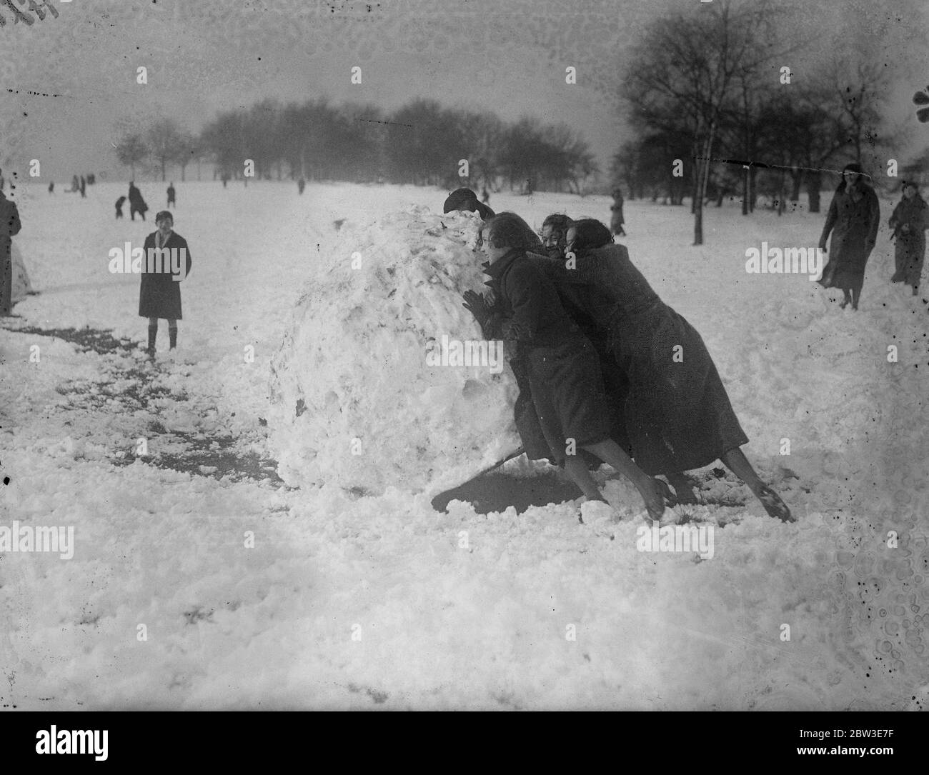Rolling a mighty snowball by winter sports enthusiasts on Parliament Hill . . 27 January 1935 Stock Photo