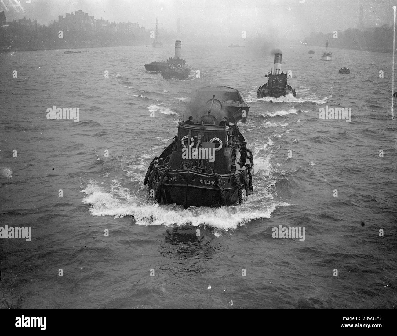Rough seas on the Thames . Rough winds are causing rough seas in the Thames , and smaller vessels are finding their course more difficult than usual . Photo shows , Tugs churning through the choppy Thames near Albert Bridge . 27 December 1935 Stock Photo