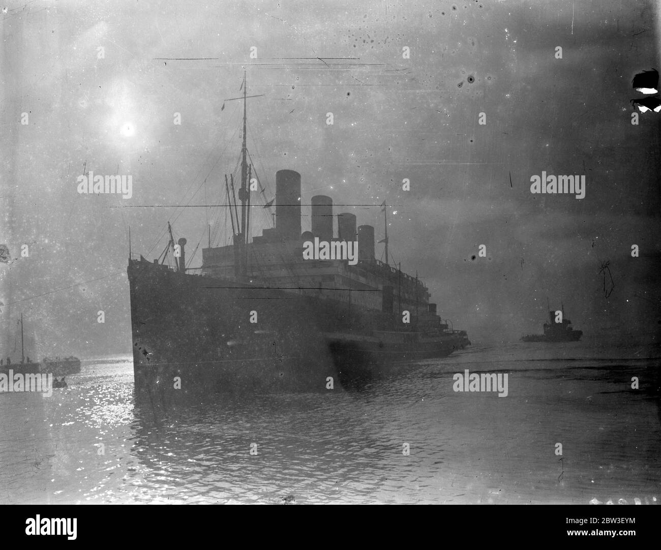 Aquitania was held up for sixteen and a half hours at Cowes by the dense fog . Photo shows the Aquitania docking in the fog at Southampton . 21 December 1935 Stock Photo
