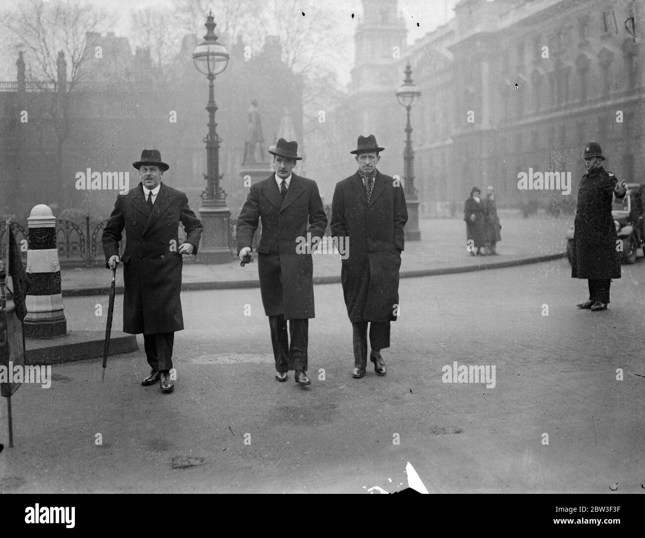 Eyes of the world on Anthony Eden as he arrives to make Rhineland statement at the House of Commons . Mr Anthony Eden , the Foreign Minister , went to the House of Commons to make his statement on Britain ' s attitude to the situation created by Hitler ' s re occupation of the Rhineland zone . Photo shows , Mr Anthony Eden arriving at the House of Commons with Mr Grimsby Gore , First Commissioner of Works ( left ) and Lord Cranbourne , Parliamentary Under Secretary for Foreign Affairs . 9 March 1936 Stock Photo