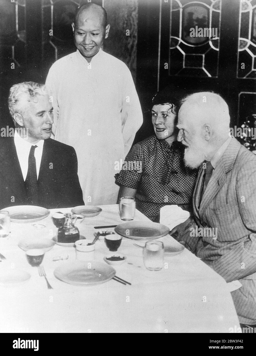 Charles Chaplin , now engaged to Paulette Goddard , lunches with Bernard Show in Honolulu . Charles Chaplin , famous film comedian , who is now reported definitely engaged to Paulette Goddard , his leading Lady in in ' Modern Times ' , lunched with George Bernard Shaw in Honolulu where Chaplin made a stay with his fiancee and her mother , Mrs Alta Goddard , during their holiday tour . It is stated that Chaplin kept GBS waiting for 35 minutes in front of the Royal Royal Hawaiian Hotel and that Mr Shaw sputtered and fumed with rage ! Photo shows , Charles Chaplin and George Bernard Shaw lunching Stock Photo
