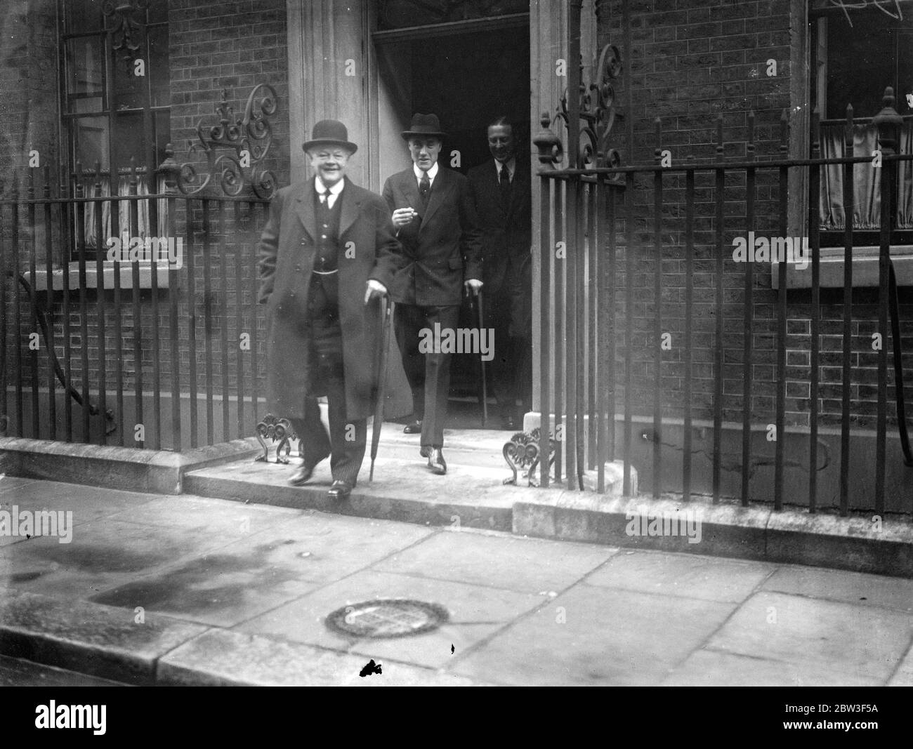 Ministers leave after Cabinet meeting . A Cabinet meeting was held at Downing Street when the situation brought about by Germany ' s reoccupation of the Rhineland was considered . Photo shows , Lord Hailsham , the Lord Chancellor ( left ) and Lord Swintop , the Air Minister , leaving after the meeting . 9 March 1936 Stock Photo