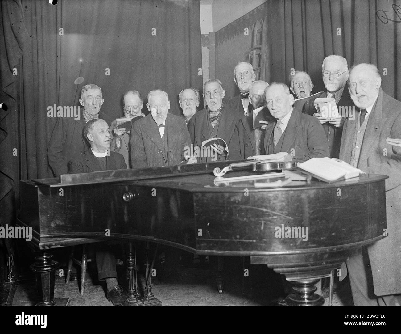 Boys of the ' Old Brigade ' to broadcast ' Grandfathers Club ' on the air ( radio ) . Members of the choir rehearse with the Reverend J A Klaiber ( at piano ) for their broadcast at Holloway . 25 January 1935 Stock Photo