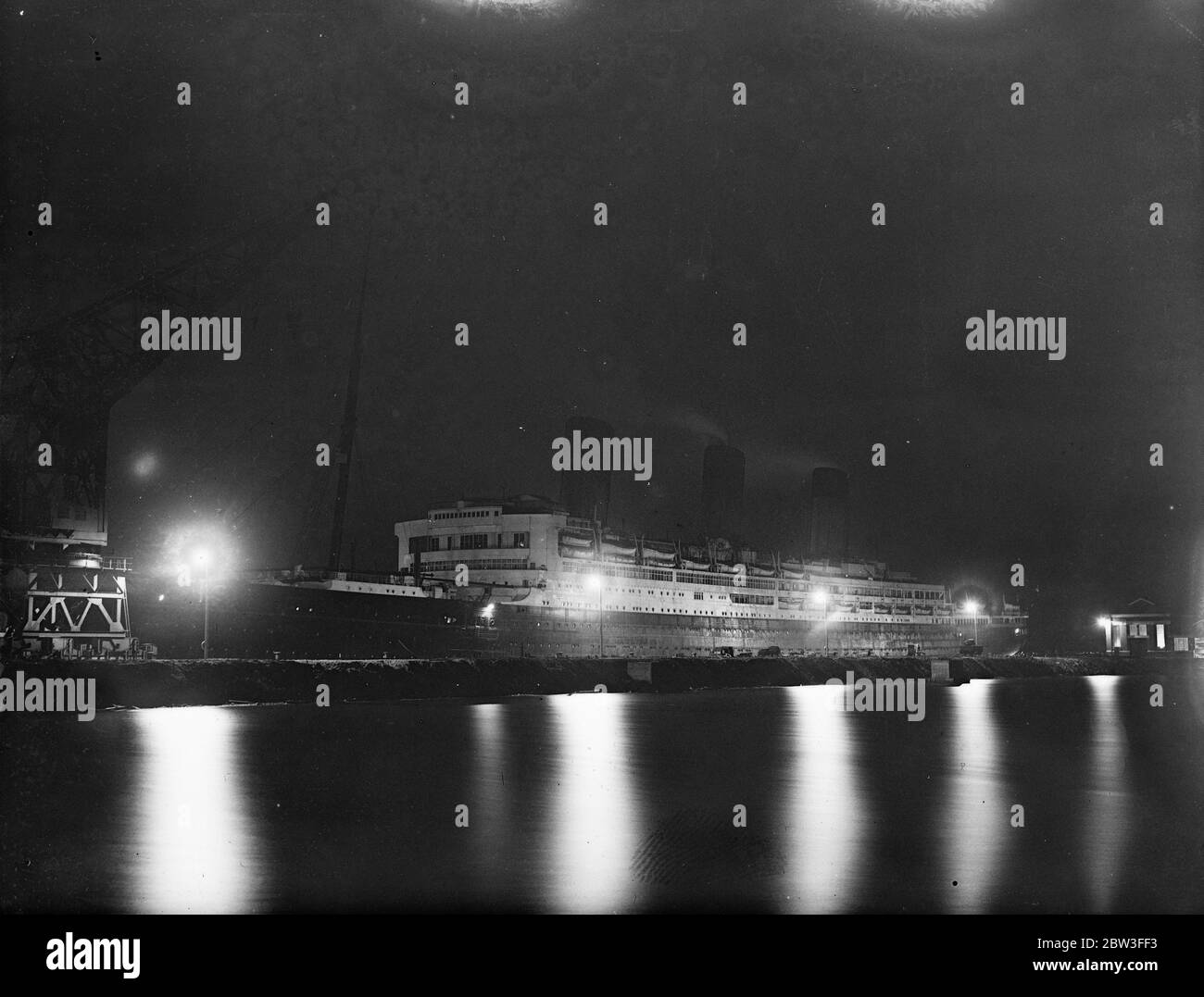 The passenger liner  SS Majestic  under powerful lights in drydock at Southampton . 25 January 1935 Stock Photo