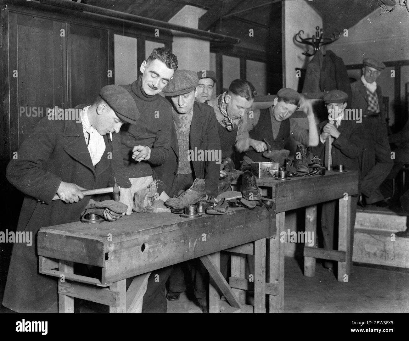 James Houston , novelist , runs centre for workless . Seen serving boys with refreshments at the Genville Hut in Battersea as they mend shoes . 5 February 1935 Stock Photo