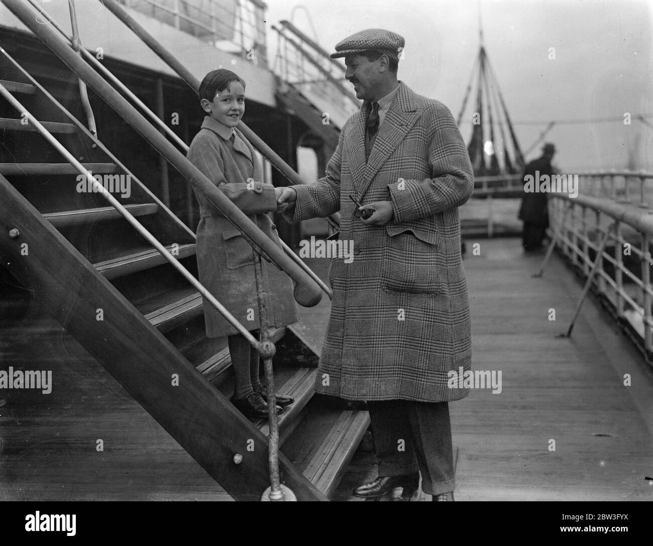 8 year old Billy Wallace shakes hands with his father as he sails on Berengaria for New York . 6 February 1935 Stock Photo