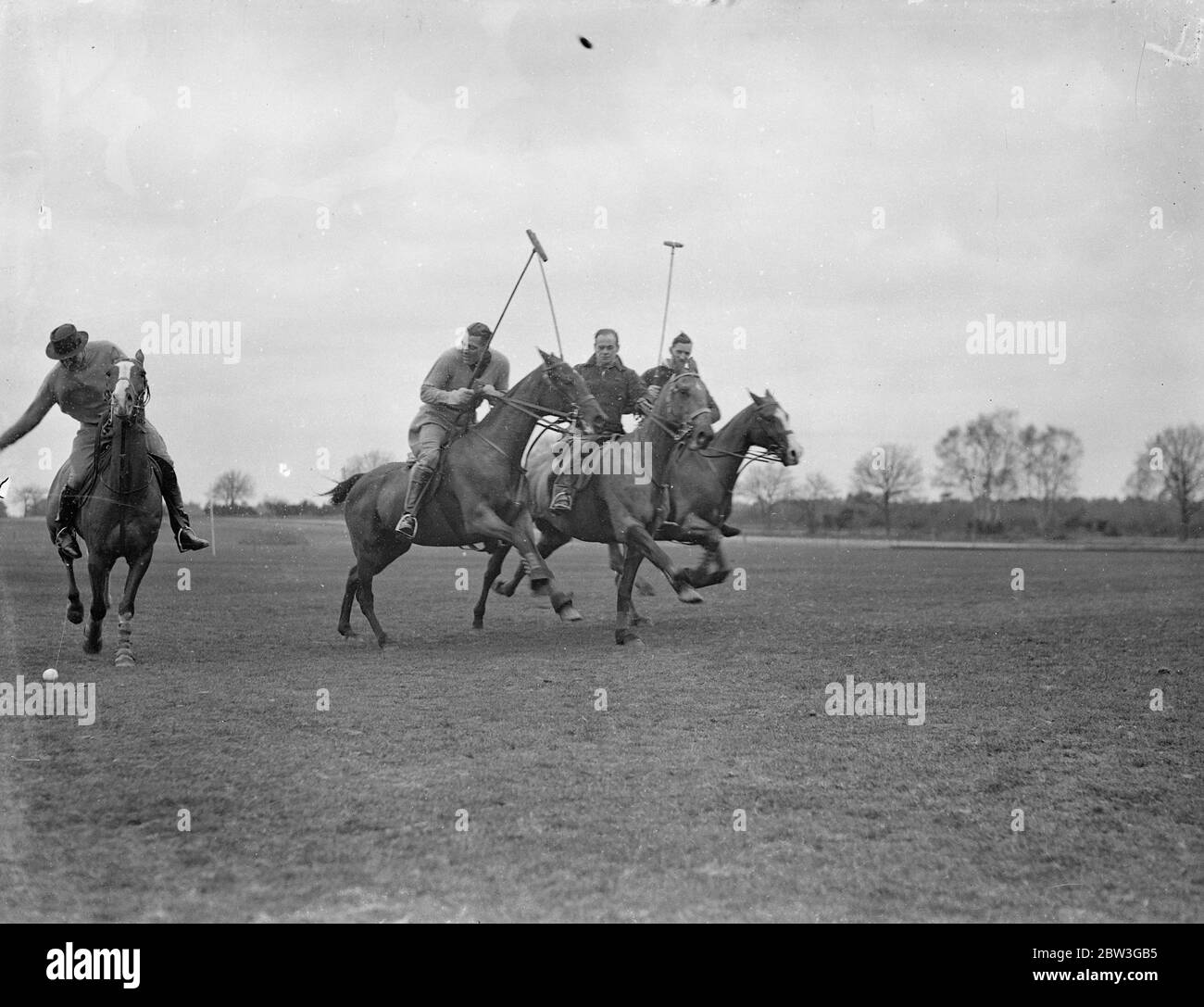 English polo team practice at Aldershot for matches with America . The English polo team which is to meet America in a series of matches for the International Polo Cup are practising at Ball Hill Polo Ground , in Aldershot . The matches are to take place at Hurlingham this summer . The trophy , one of the most coveted in the game , is at present held by America . Photo shows , British polo players practising at Ball Hill Ground , Aldershot , for the international matches , left to right , Captian Humphrey Guinness ( Royal Scots Greys ) , Captain Eric Tyrell Martin ( Captain ) , Captain M P Ans Stock Photo