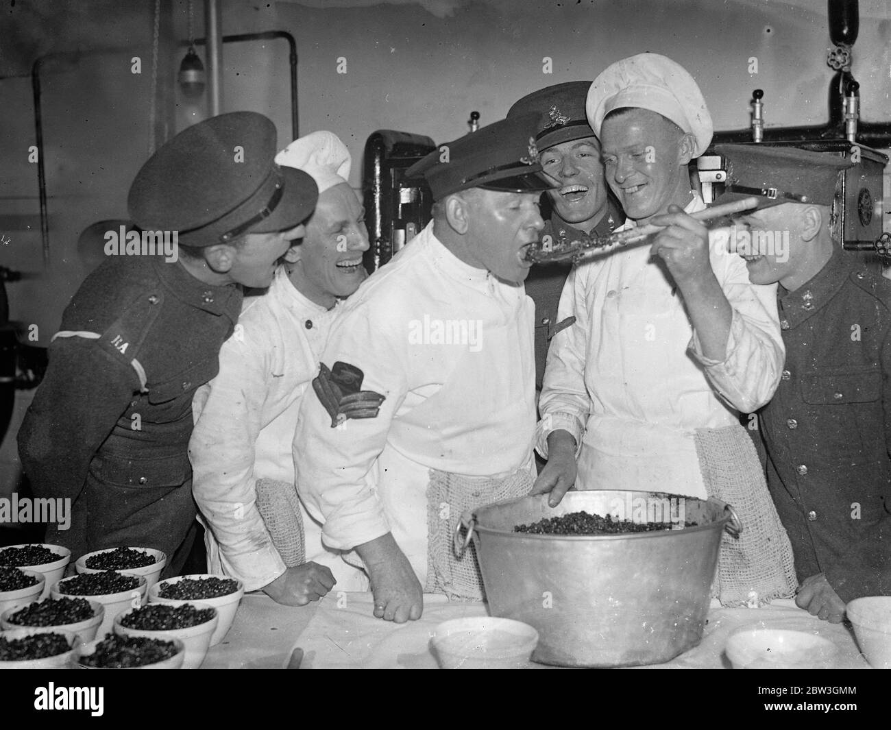 Woolwich barracks troops are making their own christmas pudding . For the first time men of the Royal Artillery at Woolwich Barracks are making their own Christmas puddings instead of buying them from outside . Six hundred men have to be catered for in the messroom and the work of preparing and mixing the puddings has already commenced . Liberal quantities of brand and stout are the most popular ingredients . Photo shows , the Sergeant cook has first taste in the kitchens at Woolwich barracks . 7 December 1935 Stock Photo