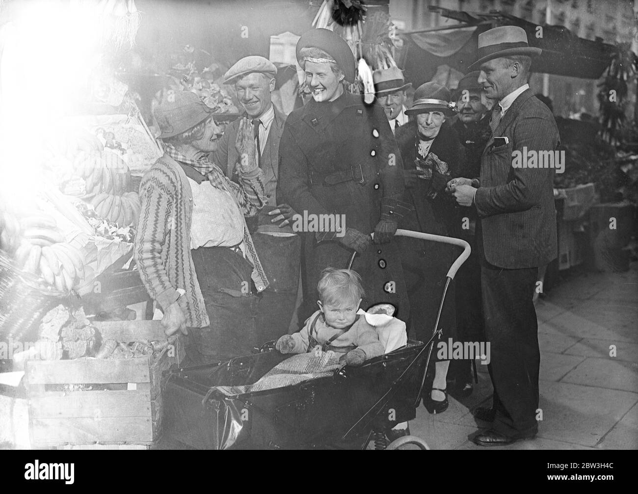 Socialist daughter in law of peer starts election campaign in St George's , Westminster . The Hon Mrs Christopher Fremantle canvassing stall holders in Lupus Street , with her son , Adam . 25 October 1935 Stock Photo