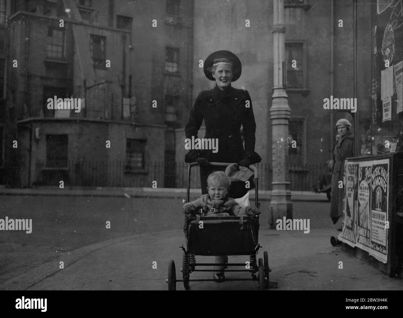 Socialist daughter in law of peer starts election campaign in St George's , Westminster . The Hon Mrs Christopher Fremantle canvassing stall holders in Lupus Street , with her son , Adam . 25 October 1935 Stock Photo