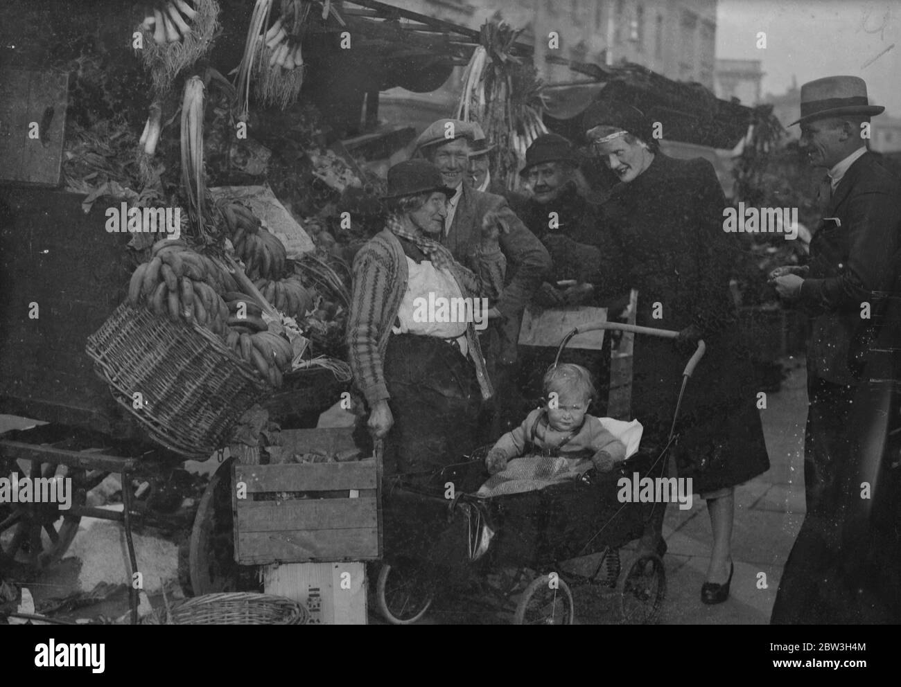 Socialist daughter in law of peer starts election campaign in St George's , Westminster . The Hon Mrs Christopher Fremantle canvassing stall holders in Lupus Street , with her son , Adam . 25 October 1935 Stock Photo