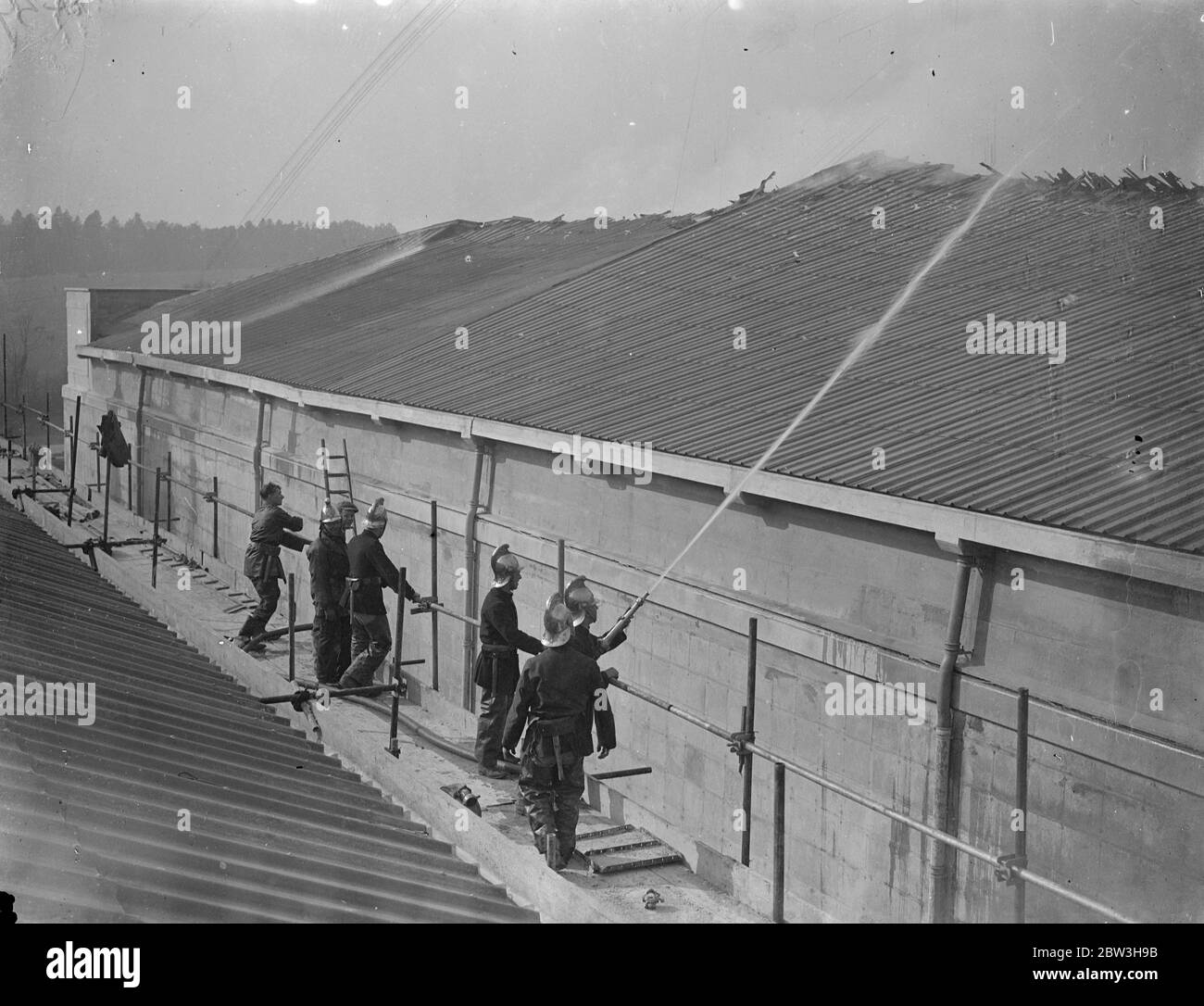 Fire rages at new Denham film studios , Buckinghamshire . Firemen fighting the blaze . 17 March 1935 Stock Photo