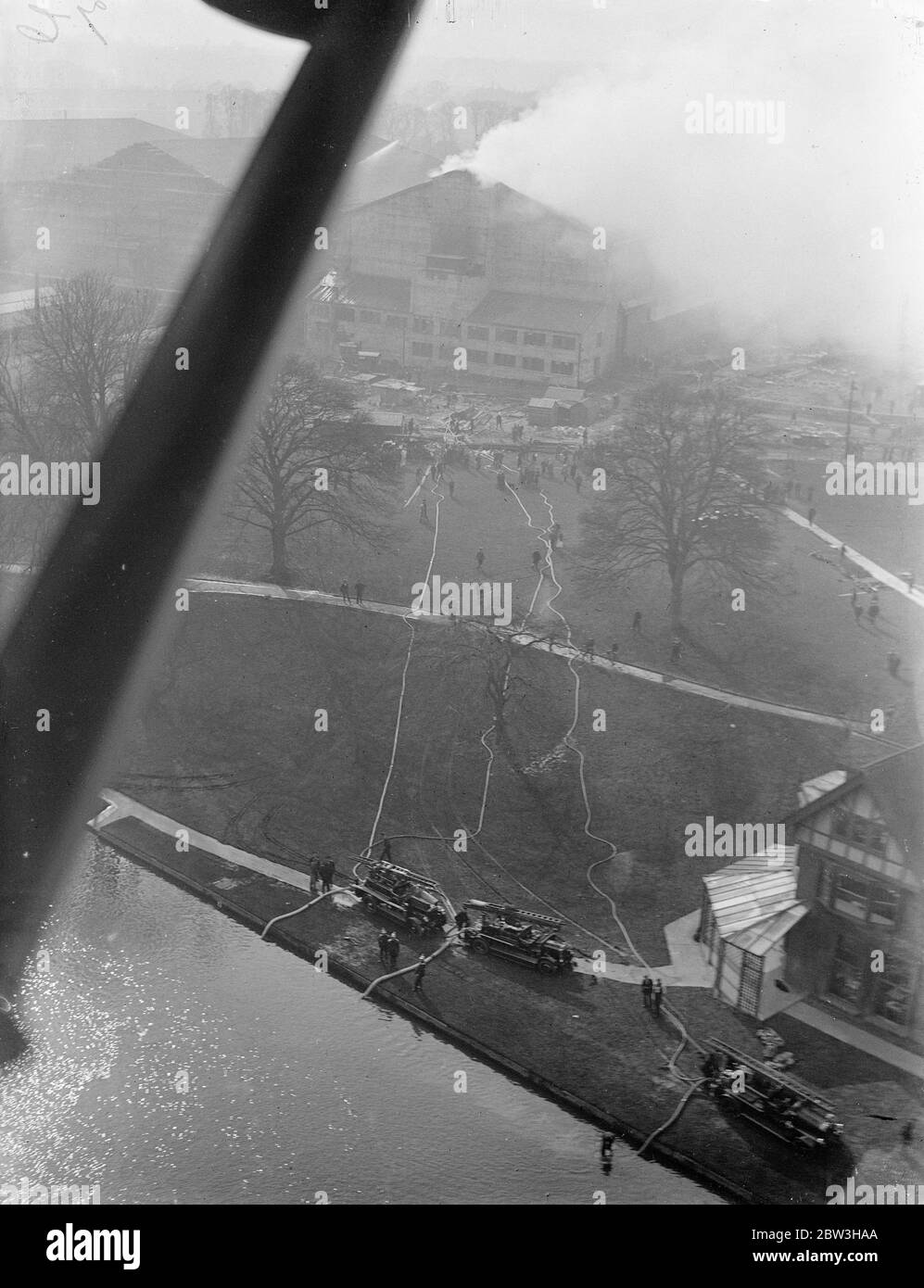 Fire rages at new Denham film studios , Buckinghamshire . An aerial view of the fire showing the great distance the firemen had to take their hoses to draw water from a pond . 17 March 1935 Stock Photo
