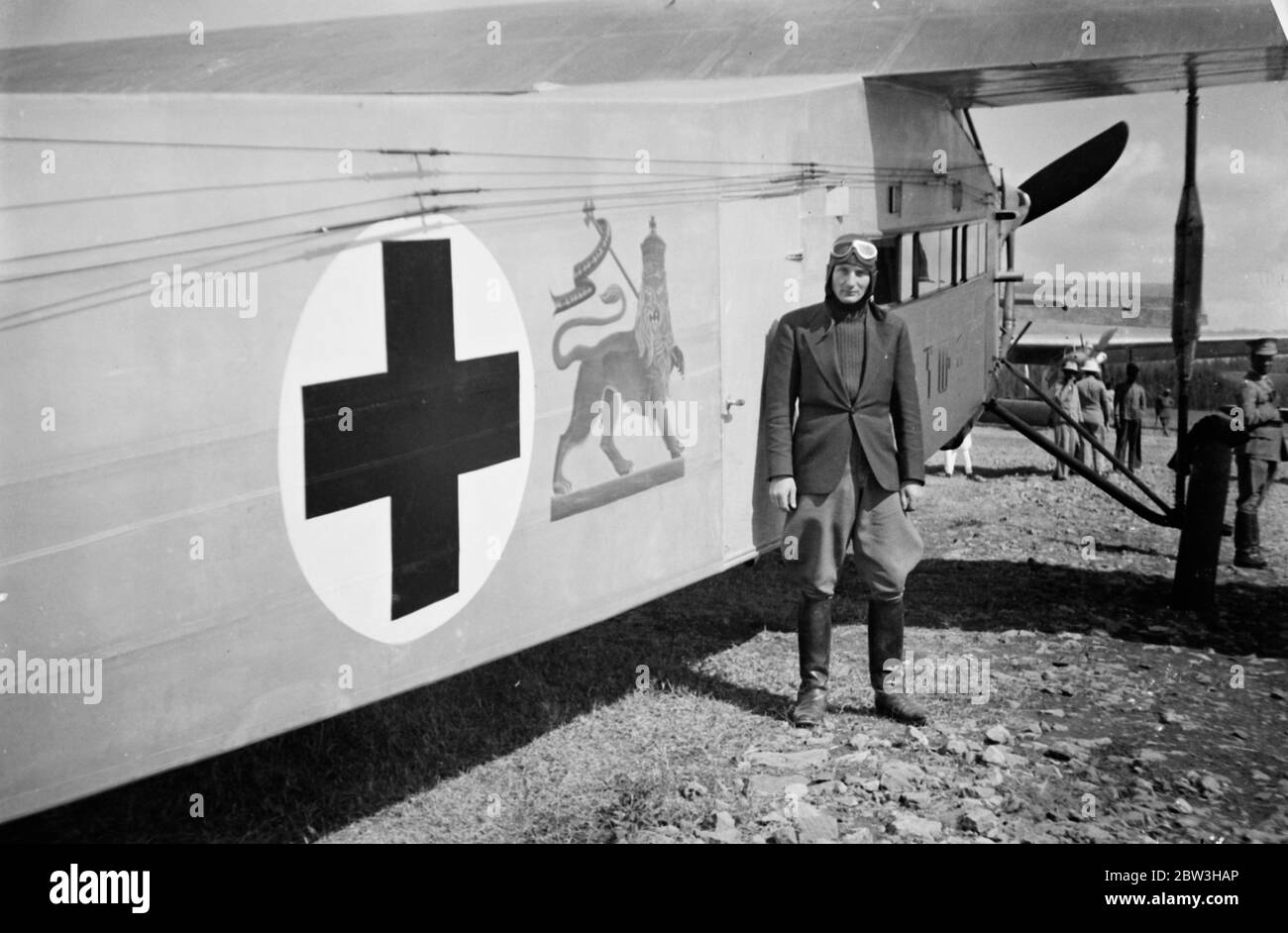Swedish airman flies victims to safety after bombing of Dolg Red Cross by Italians . These pictures of the bombing by Italian planes of the Swedish Red Cross unit at Dolo as the Abyssinian southern front , were brought to London by air . One Swedish doctor , Dr Gunnard Lundstorm , was killed , together with 50 Abyssinians . All the members of the Swedish staff were injured . The wounded were flown to Addis Ababa by Count von Rosen , a heroic Swedish pilot , who made several journeys between the capital and the scene of the air air raids . Photos shows , Count von Rosen standing beside his plan Stock Photo
