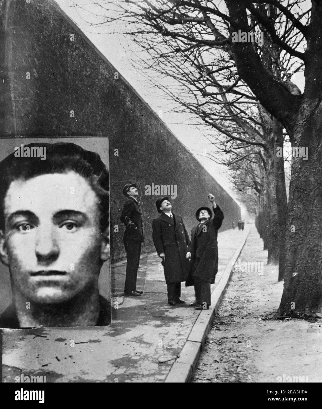 Second man in history to escape from Sante prison . Police officers pointing to the tree from which a rope was thrown to Armand Spilers so that he could scale the prison wall ( on left ) . Inset is the escaped convict . 21 March 1935 Stock Photo