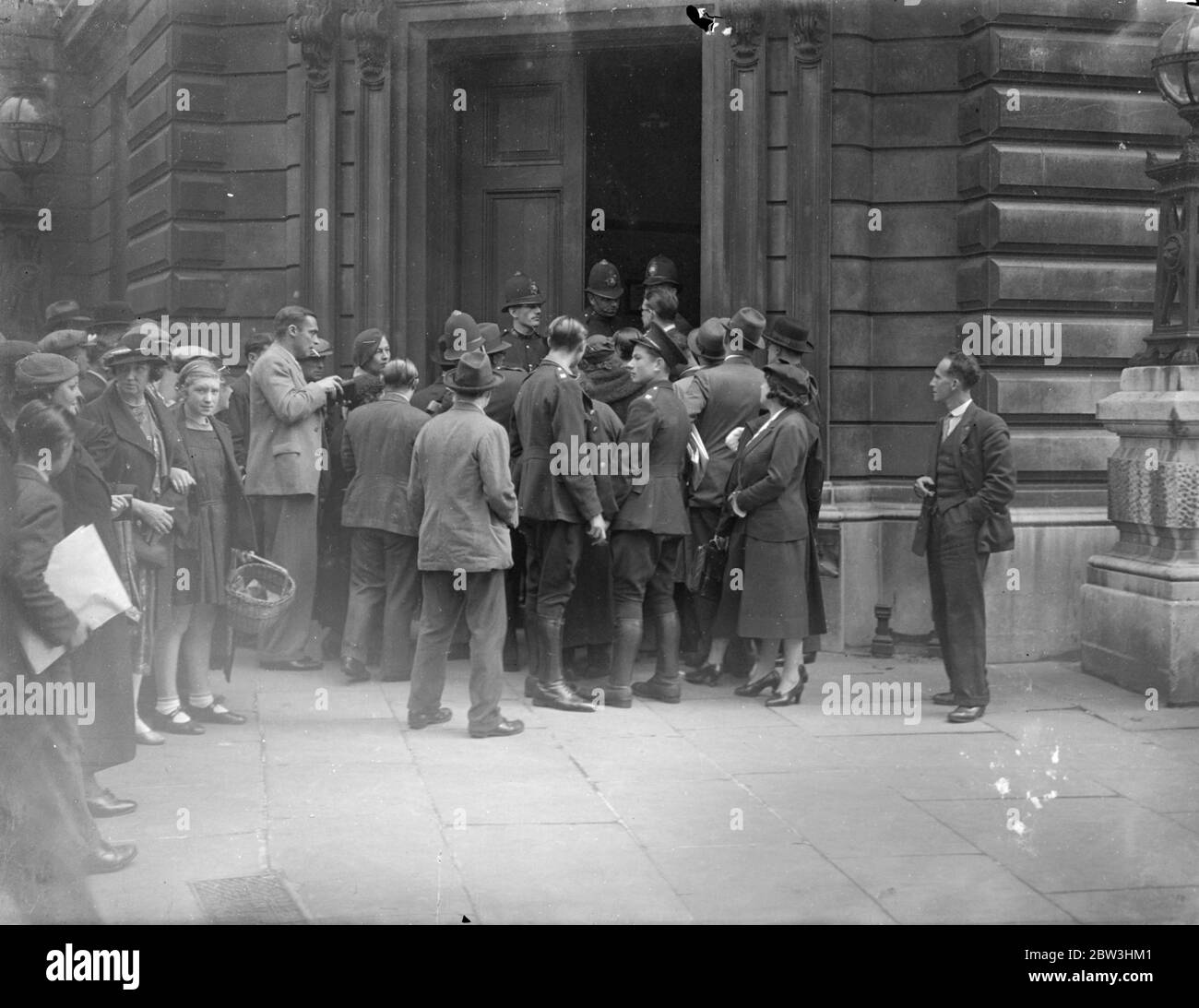 Police Close Doors At Bow Street As McMahon Appears . There was a long queue at Bow Street Police Court when the man who was arrested on Constitution Hill when the King was returning from Hyde Park after presenting new Colours to the Guards , George Andrew McMahon , appeared before the magistrate . People waited from the early hours of the morning in the hope of gaining admission to the court , but the police had close the doors long before they had all entered . Photo shows : Police closing the doors at Bow Street as people tried to enter . 24 Jul 1936 Stock Photo
