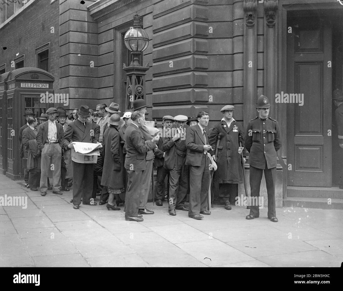 Big Crowds At Bow Street When McMahon Appears - But Police Admited Only 20 . Although a long queue waited from the early morning , police admitted only 20 people to Bow Street Police Court when George Andrew McMahon [ alias of Irish fraudster Jerome Bannigan ] , the man who was arrested on Constitution Hill when the King was returning from Hyde Park , appeared before the magistrate . Photo shows : The big crowd outside Bow Street Police Court . 24 Jul 1936 Stock Photo