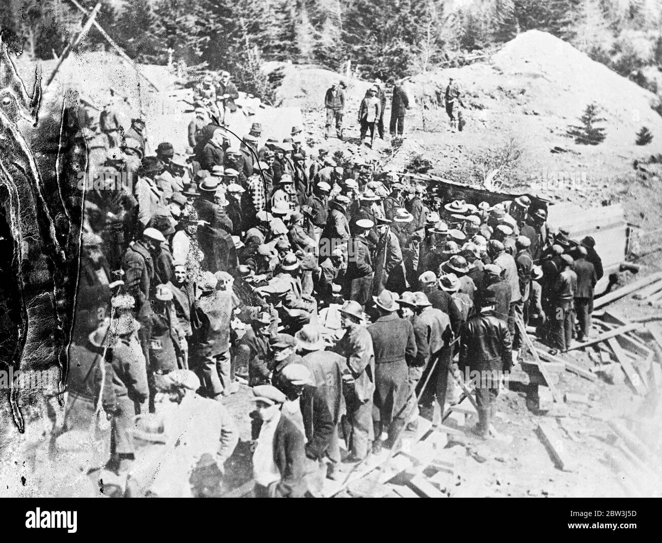 New picture of entomed men . Ten days in Moose river gold mine . Few hours from life . Entombed for ten days , Dr D E Robertson and Charles Alfred Scadding , the two men trapped in a gold mine at Moose River , Nova Scotia , are now seperated by 12 feet of solid rock from the workers who are labouring night and day to rescue them . Time after time rescue workers have been prevented in their fight by fresh falls and insurmountable obstacles . Now they have to cut off at a slant to escape the solid wall of rock that alone keeps them from the trapped men . Food poured through a drill driven throug Stock Photo