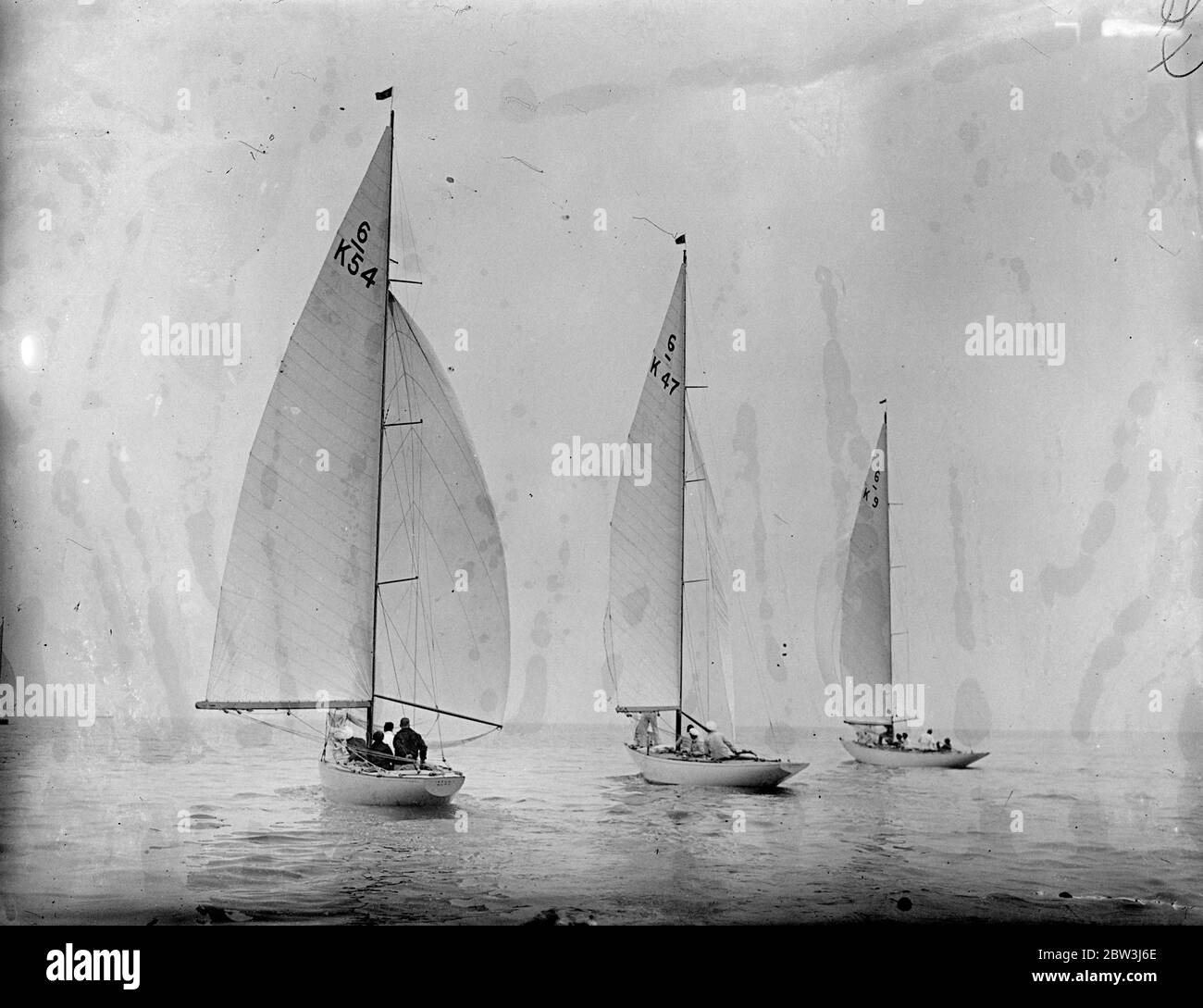 Yachts compete in Olympic games trials at Burnham on Crouch . The Olympic Games eliminating trials for six meter , monotype and star class yachts held under the suspices of the Royal Corinthian Yacht Club , took place at Burnham on Crouch , Essex . The races are being held to choose the best representatives among those entered to race at Kiel in the August Olympic games . Photo shows , sails billowing , Catherine ( H 47 ) owned by J D C Ewigg and H Ryan and Kyle ( K 54 ) F S Spriggs and Nona ( K 9 ) owned by F G Mitchell competing in the six meter class . 13 May 1936 Stock Photo