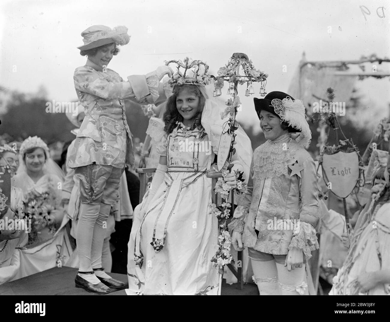 May Queen of London crowned at Hayes . Miss Olive Bone of Clapham was crowned at Hayes , Kent , as May Queen of London . The coronationwas carried out by Pauline Gillham , last year ' s Queen of Merrie England . Photo shows Olive Bone being crowned as May Queen of London by Pauline Gillham . 2 May 1936 Stock Photo