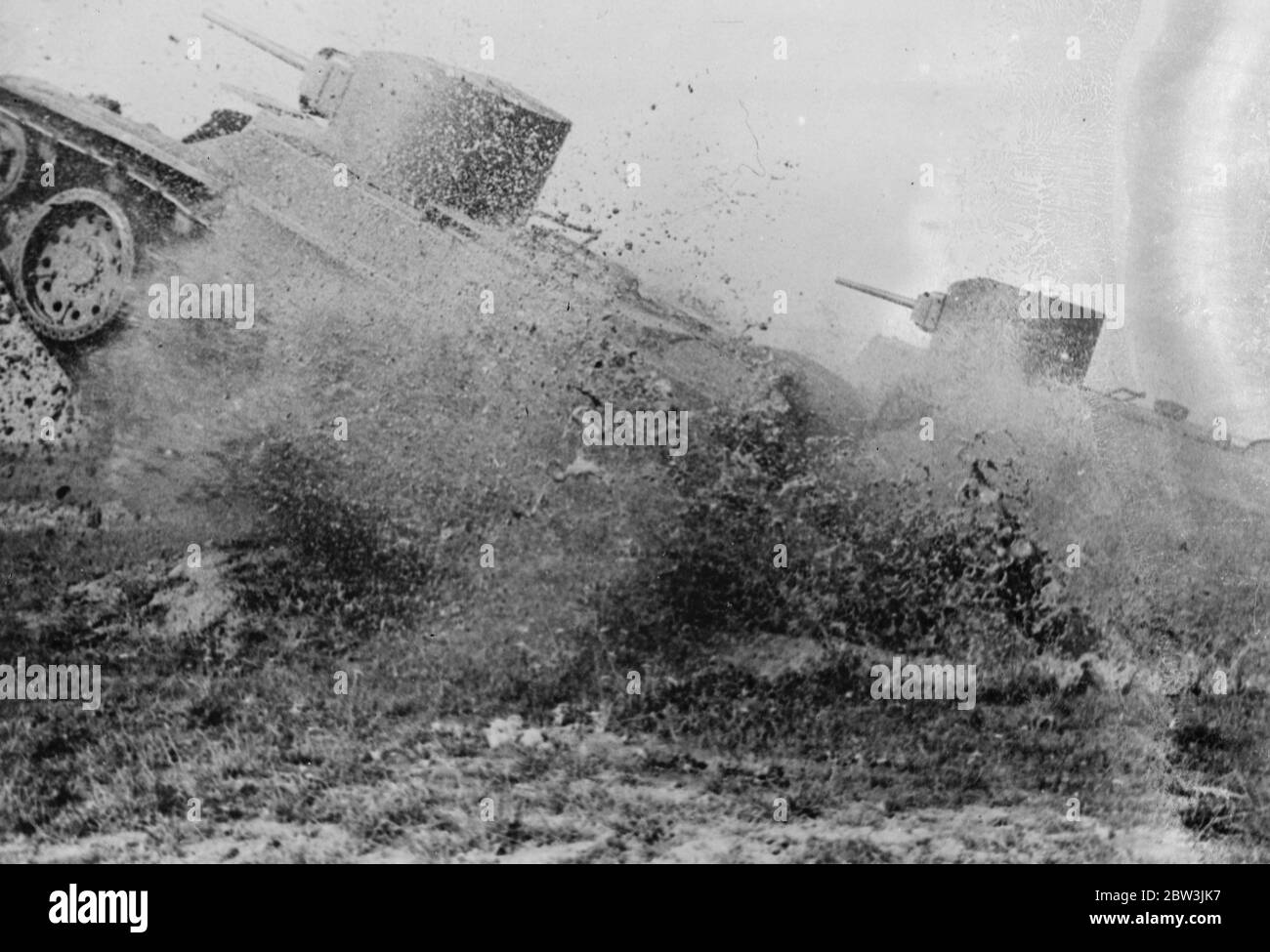Russia 's dare devil tank corps exercises provide thrills . Tanks almost screened by churned up earth as they climbed over an obstacle . 24 October 1935 Stock Photo